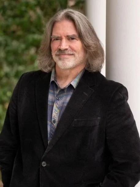 A professional headshot of Peter Cook standing outside on Princeton University campus.
