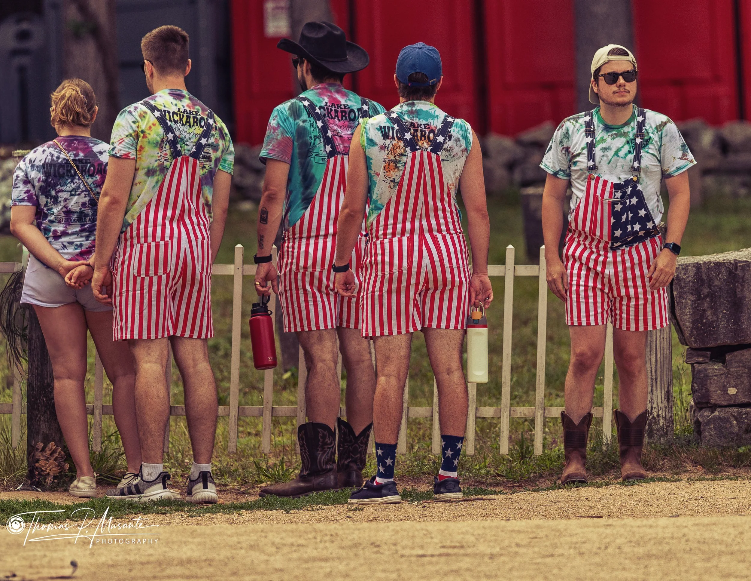 Visitors in Stars-and-Stripes Overalls Line the Picket Fence