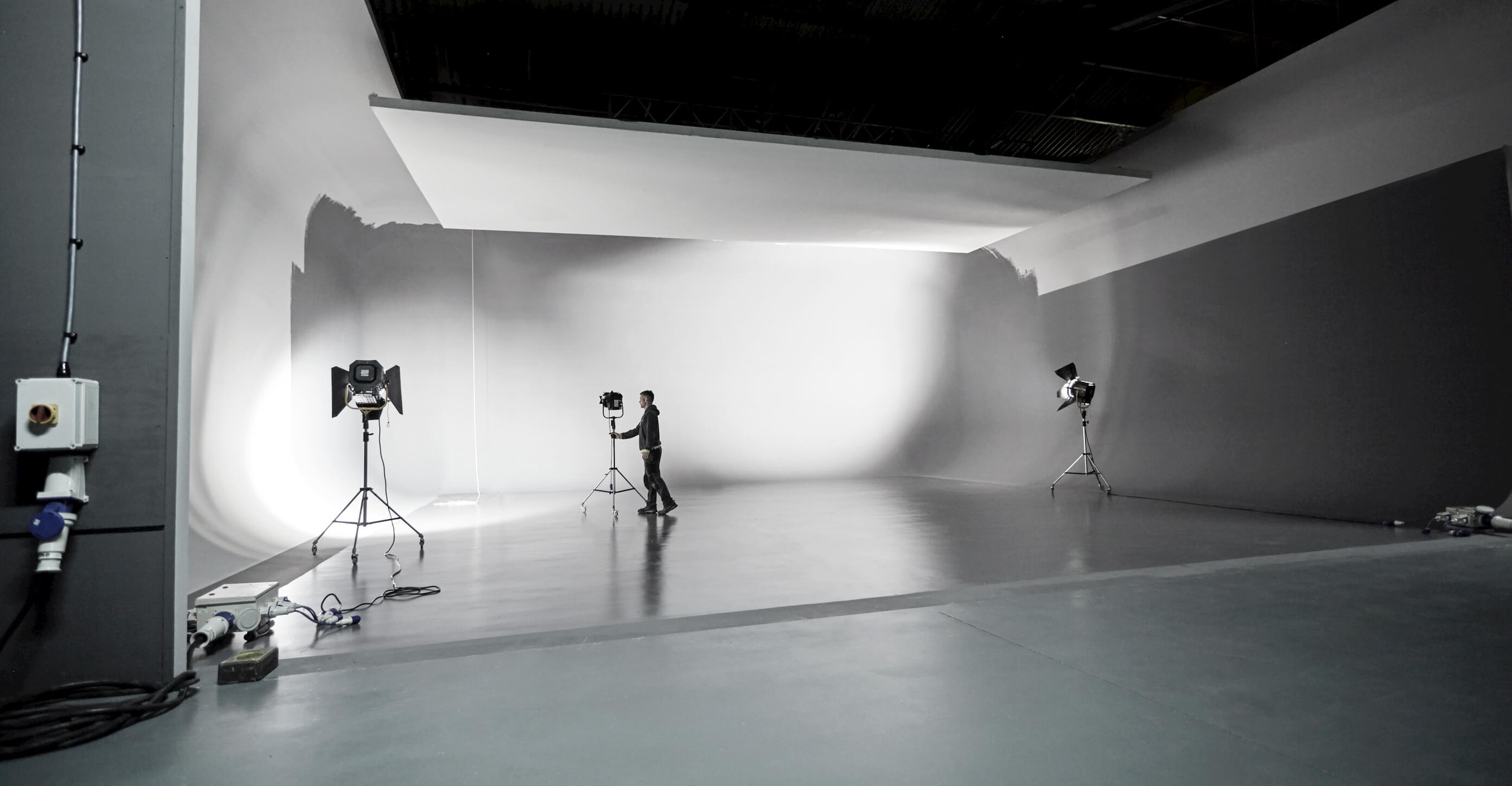 Studio-1-one-moorland-studios-large-photography-space-uk-midlands-man-moving-lighting-stand-infinity-cove.jpg