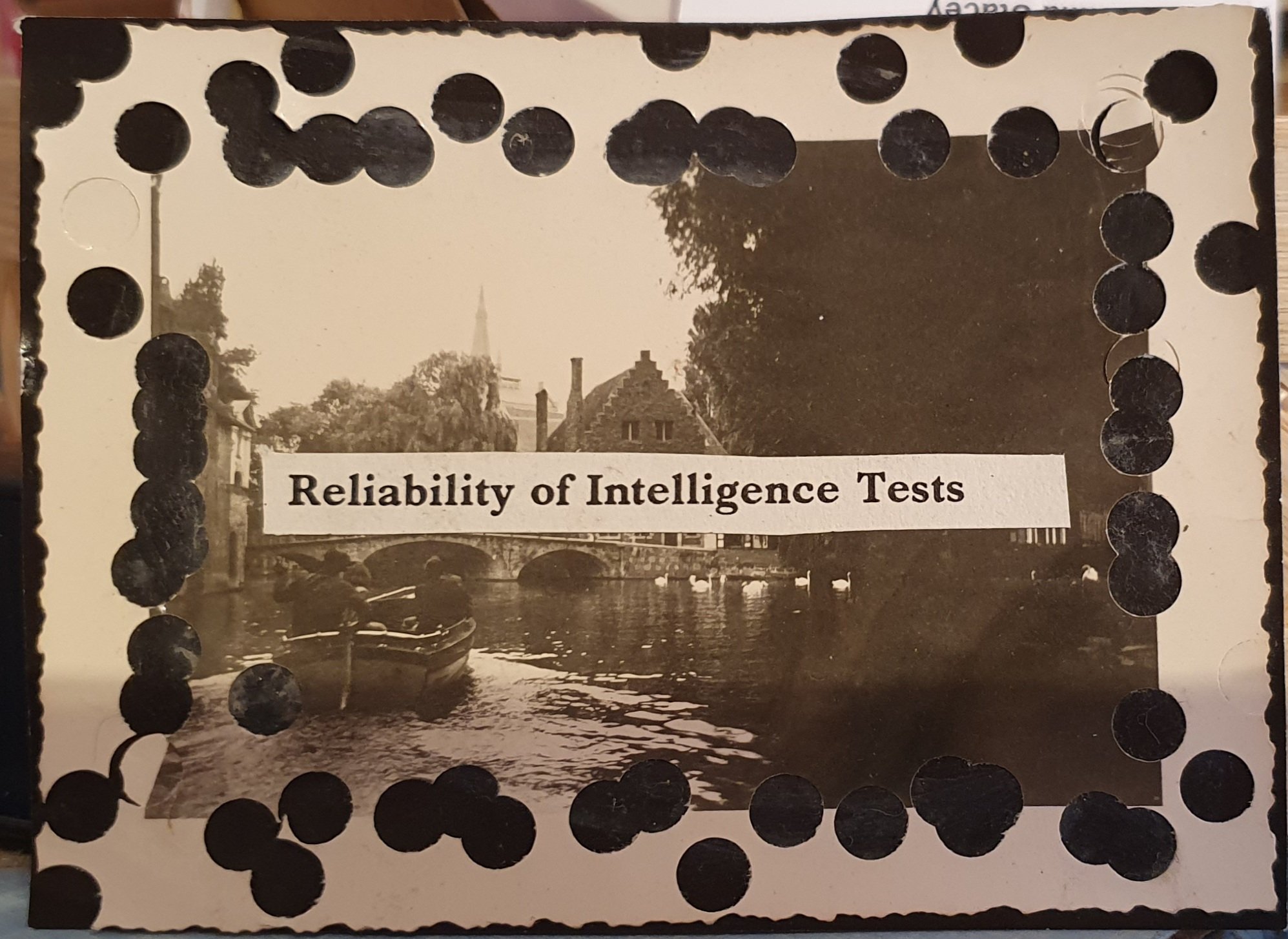 A black and white collage made using a vintage photo of people in a boat on a river. The photo has holes punched in it that show the black card it is stuck to. Covering part of the image is found text that says 'Reliability of Interlligence Tests'.