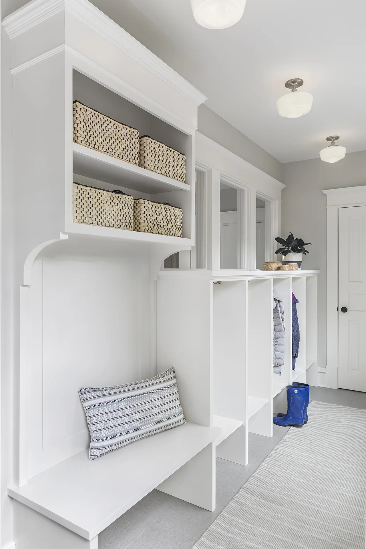 Enclosing the back stoop of the house allowed for a new mudroom space. Individual cubbies for each family member help contain clutter and a heated tile floor keeps the room cozy.