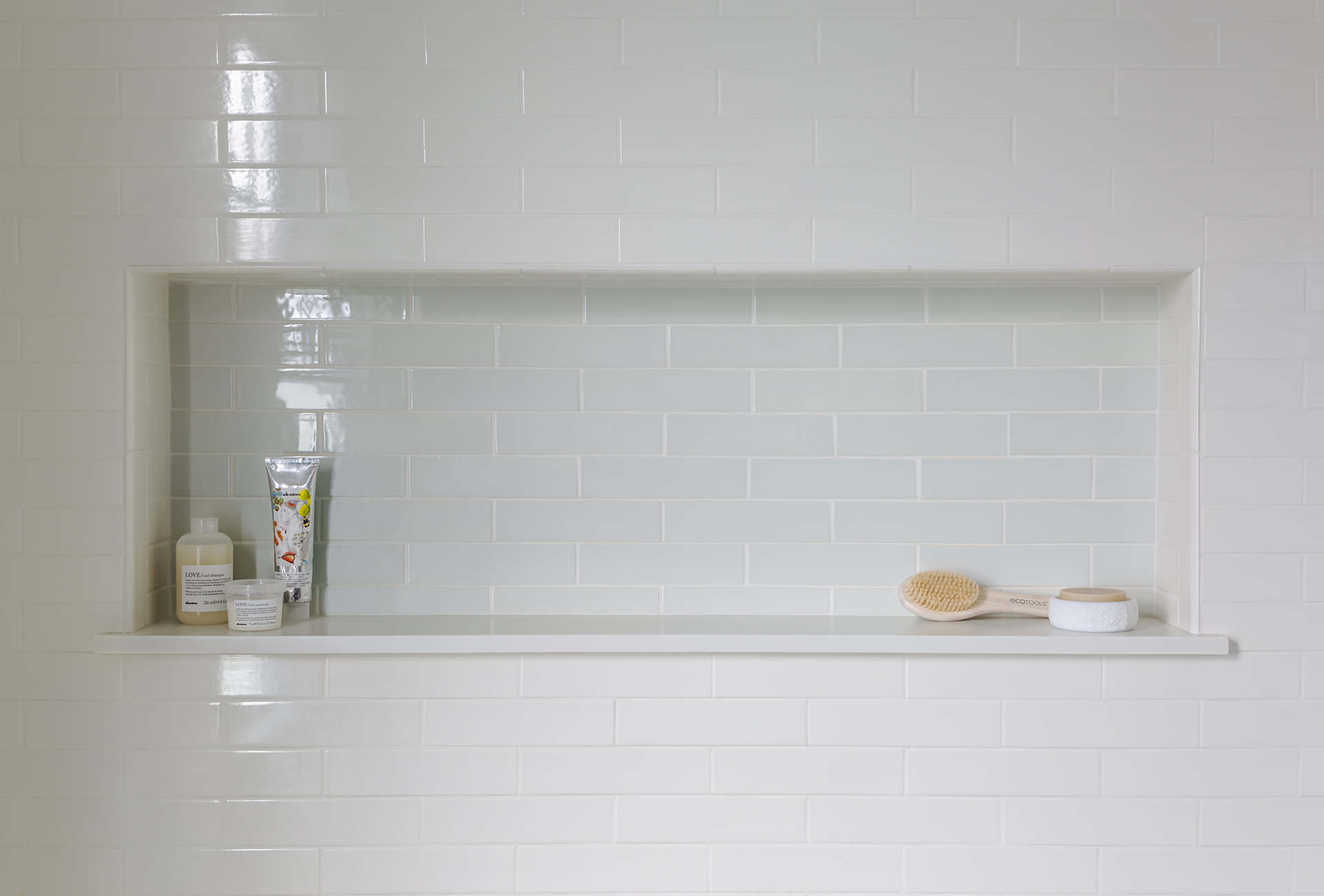 An oversized shower niche with contrasting tile provides ample storage and keeps clutter to a minimum.