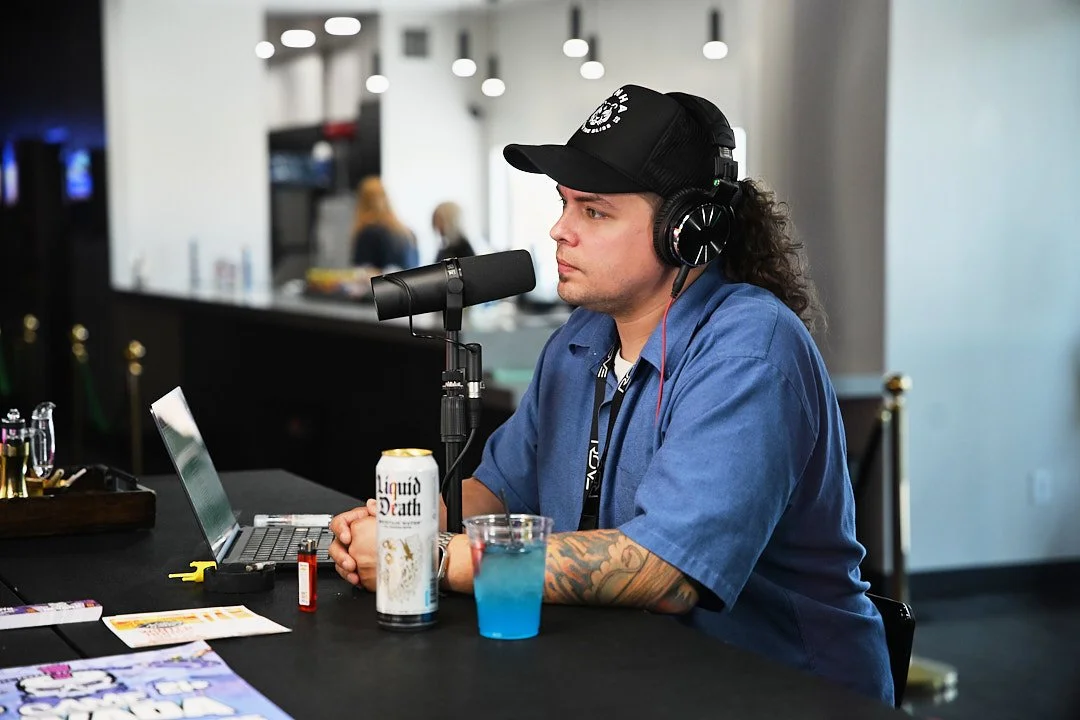 Nuwu Sessions host Tom speaks into a podcast microphone inside Sky High Lounge.