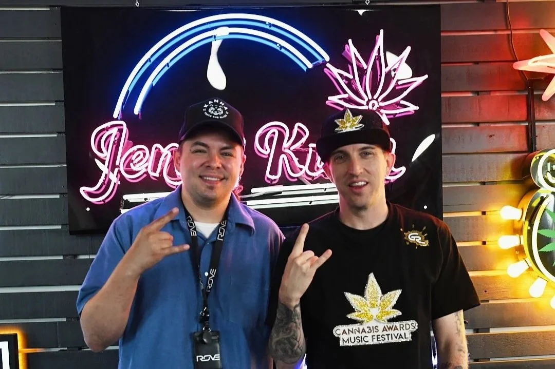 Nuwu Sessions host and guest pose beneath a neon cannabis sign inside Sky High Lounge.