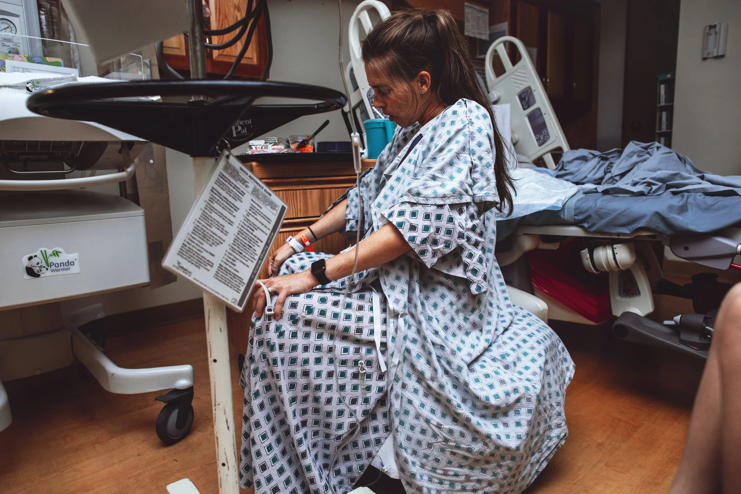 A laboring woman sits on a birthing ball inside a hospital room Jacksonville, Florida.