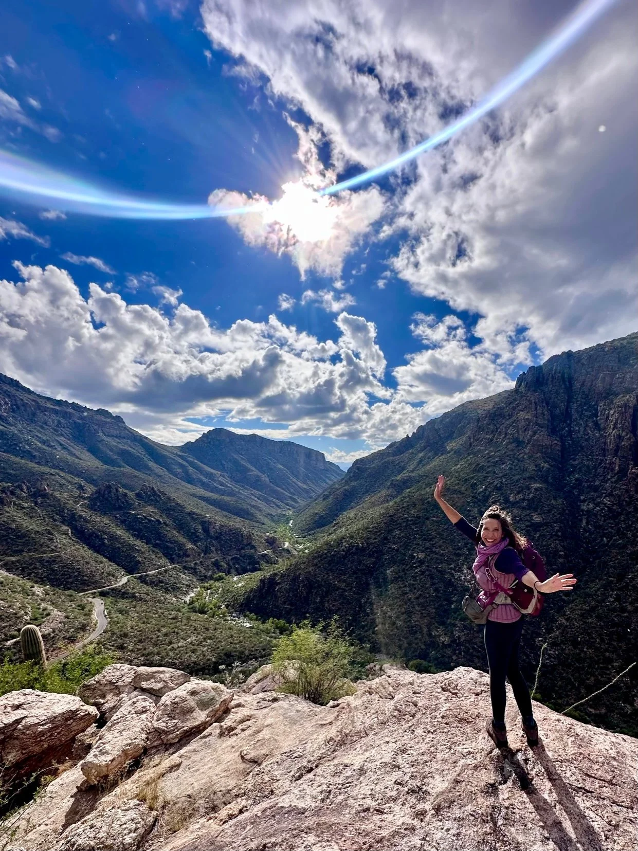 Amala with outretched arms on the top of a mountain with a sense of freedom
