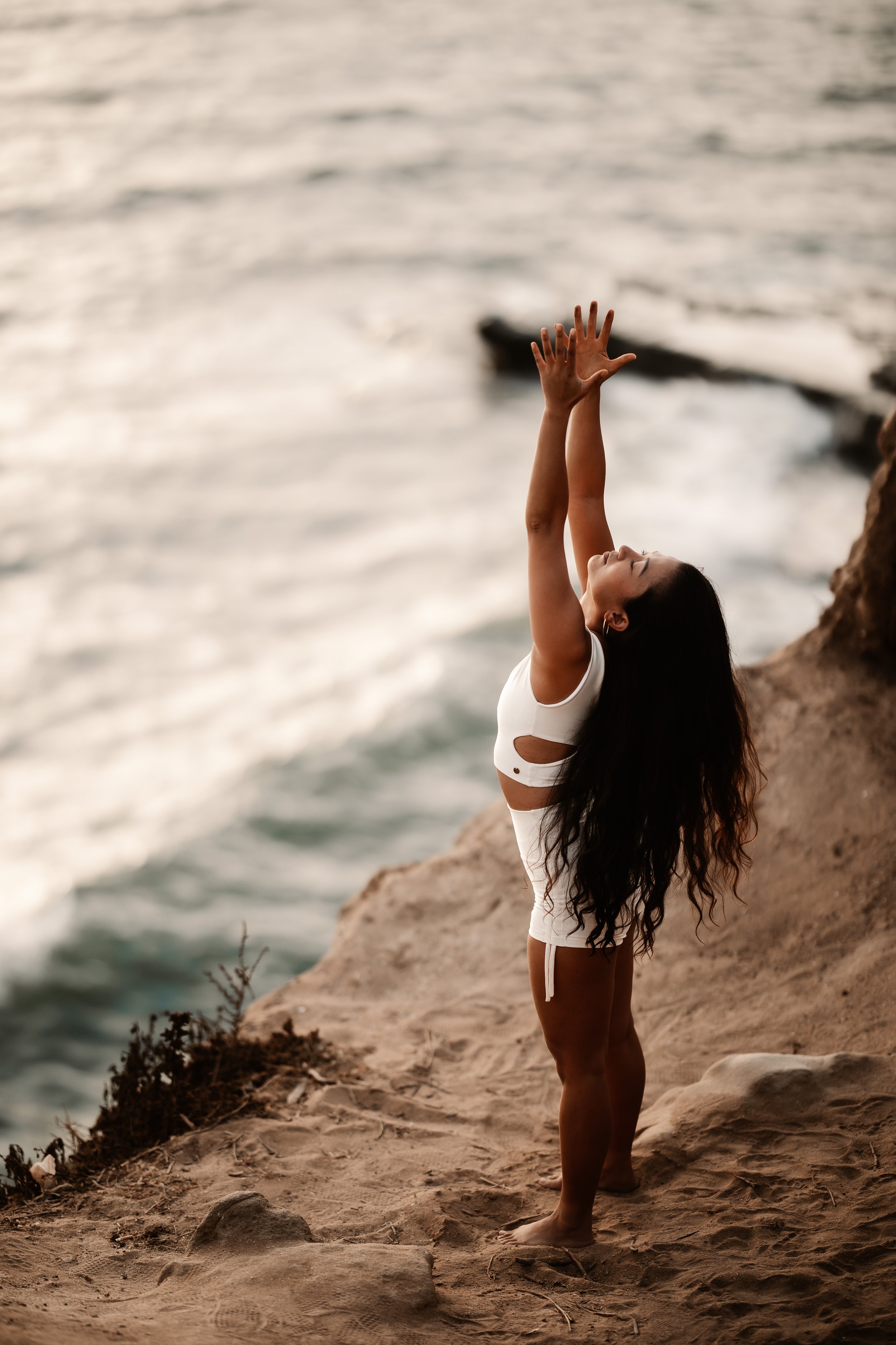 mountain pose on top cliffs by ocean