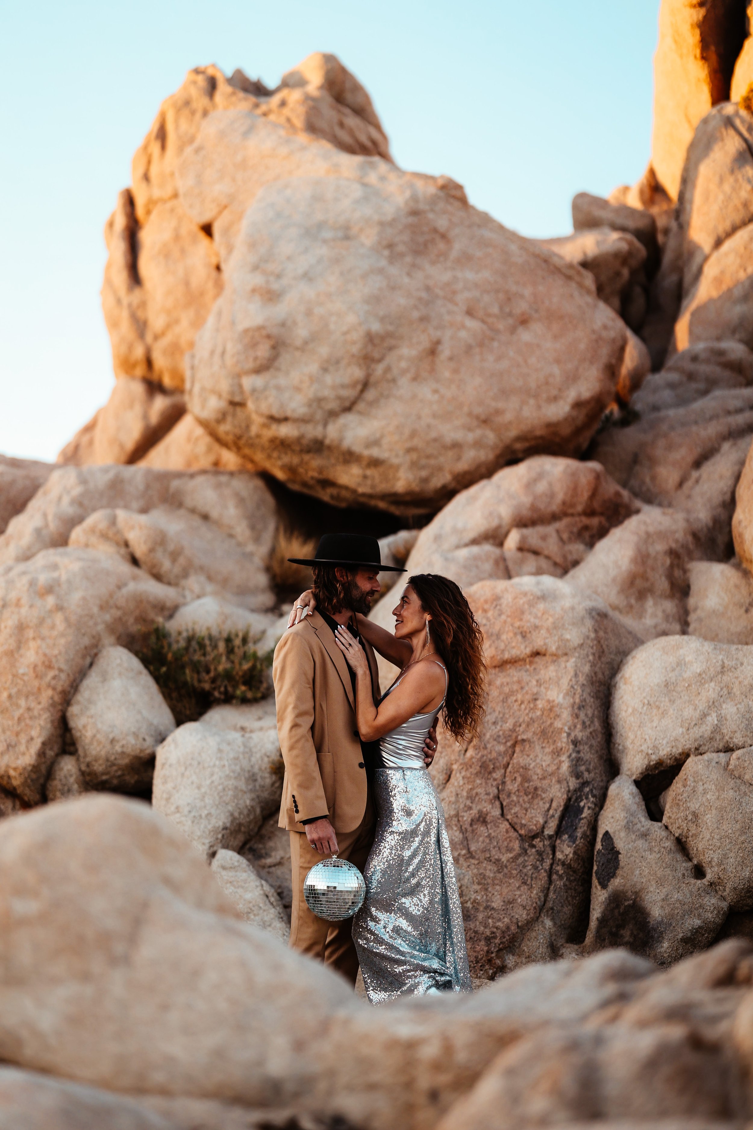 engagement couple shoot in front of rocks holding disco ball