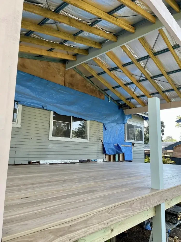 Timber deck under construction with covered roof and exposed timber beams.