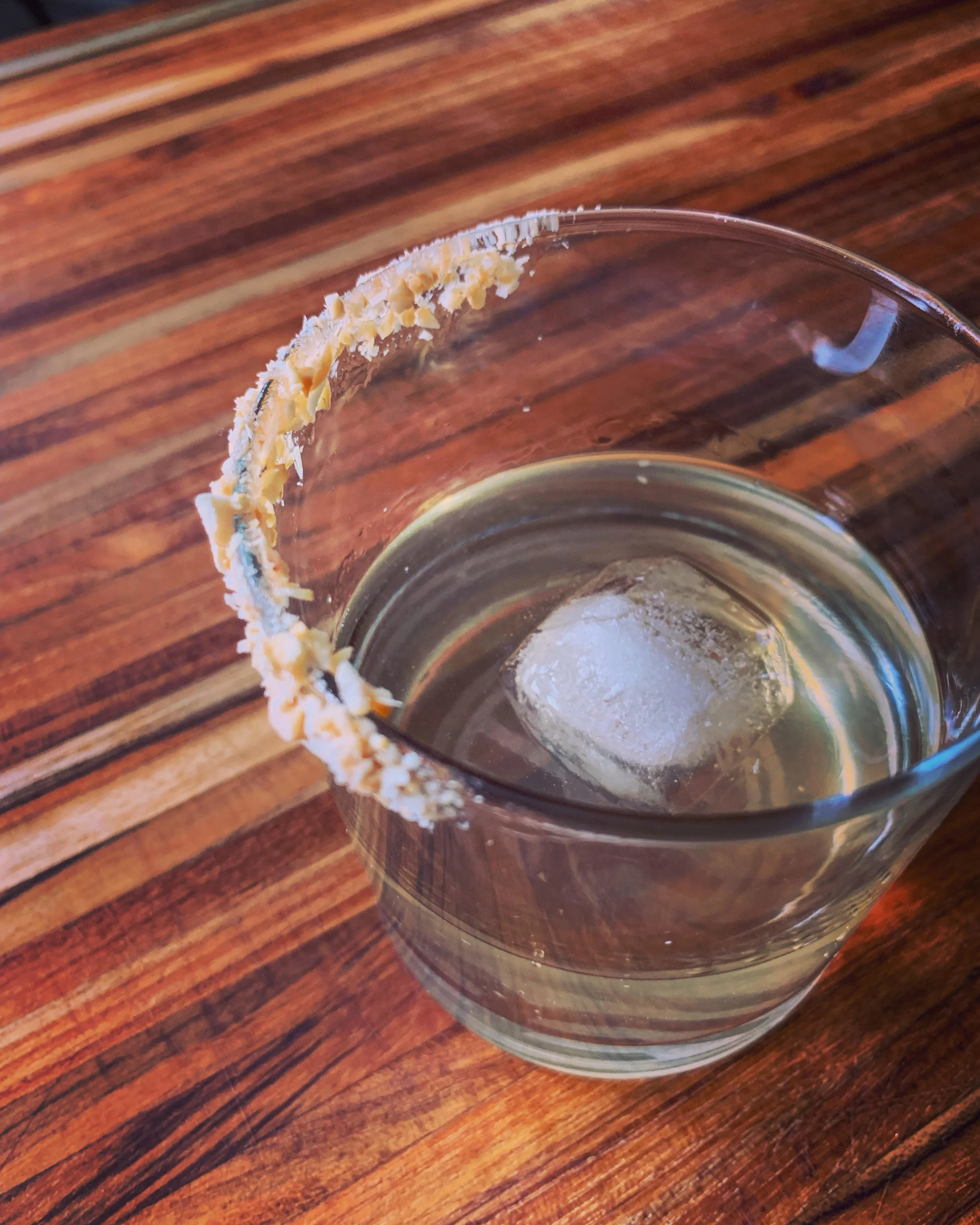 The PBJ, Jackie Gochenouer, Somerville, MA, America's Test Kitchen, @theravenousjackie 1. Thin out 1 Tbsp of grape jelly with 1 tsp water in a small bowl. Finely chop 2 Tbsp of roasted salted peanuts and transfer to small plate. 2. Dip the rim of your glass into the thinned-out jelly, then dip into the chopped peanuts. 3. Shake 2 oz grape vodka, 2 oz hazelnut liqueur, and 1/2 tsp pineapple juice with ice. Strain into rimmed glass and serve with ice.