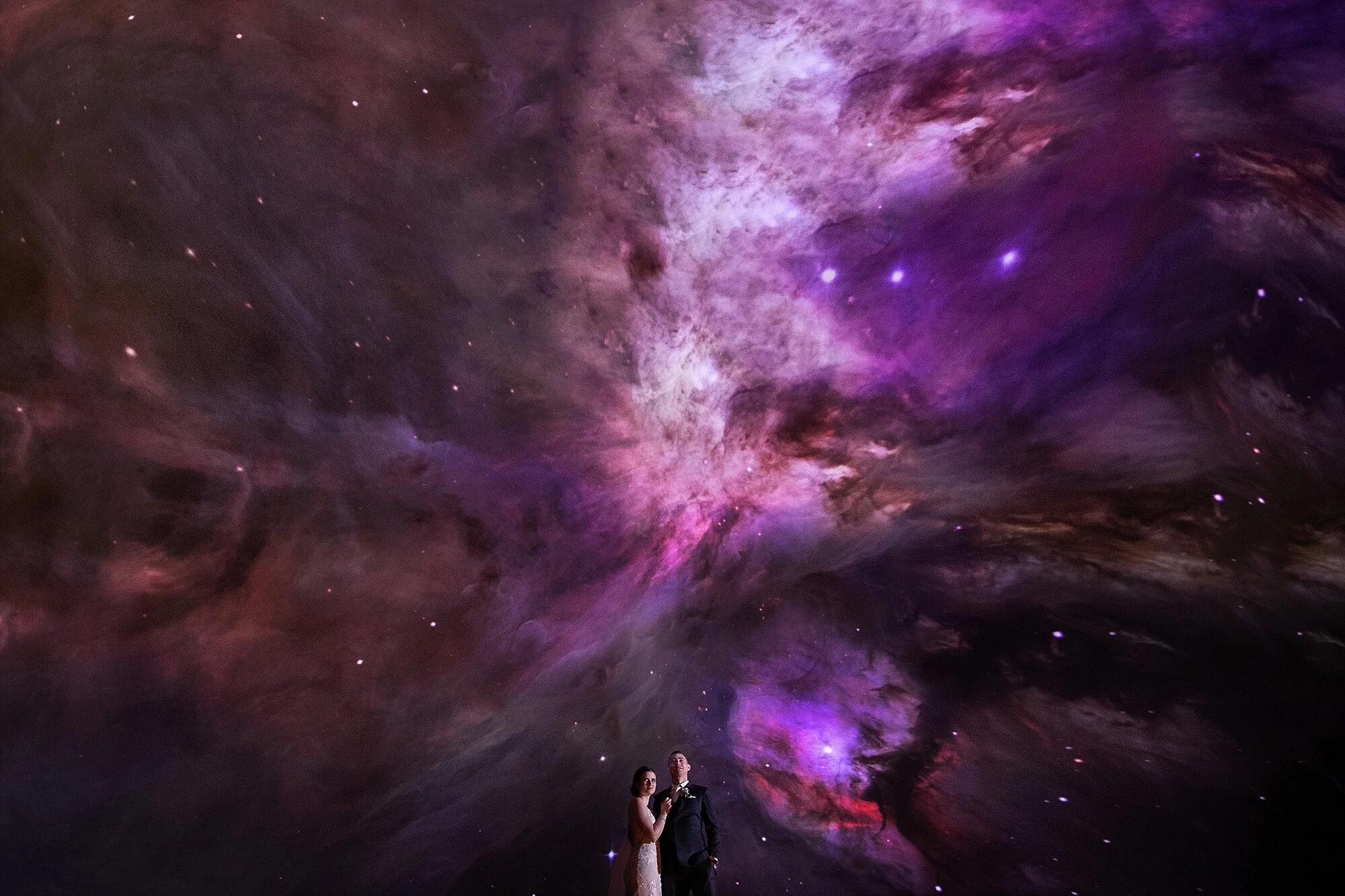Bride and Groom portraits at telus world of science wedding in edmonton in front of planetarium screens