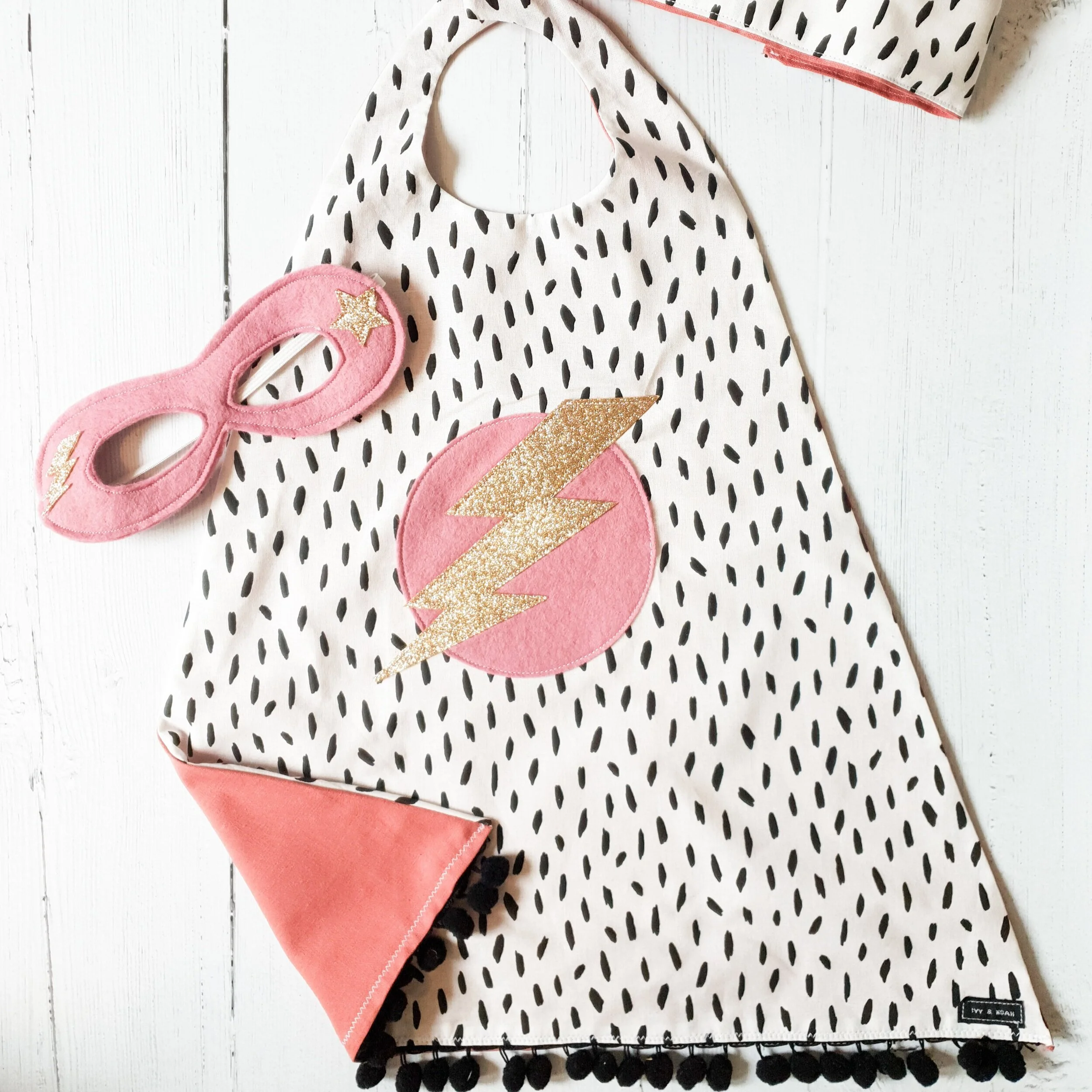 Monochrome spot and pink superhero cape, mask and crown gift set.