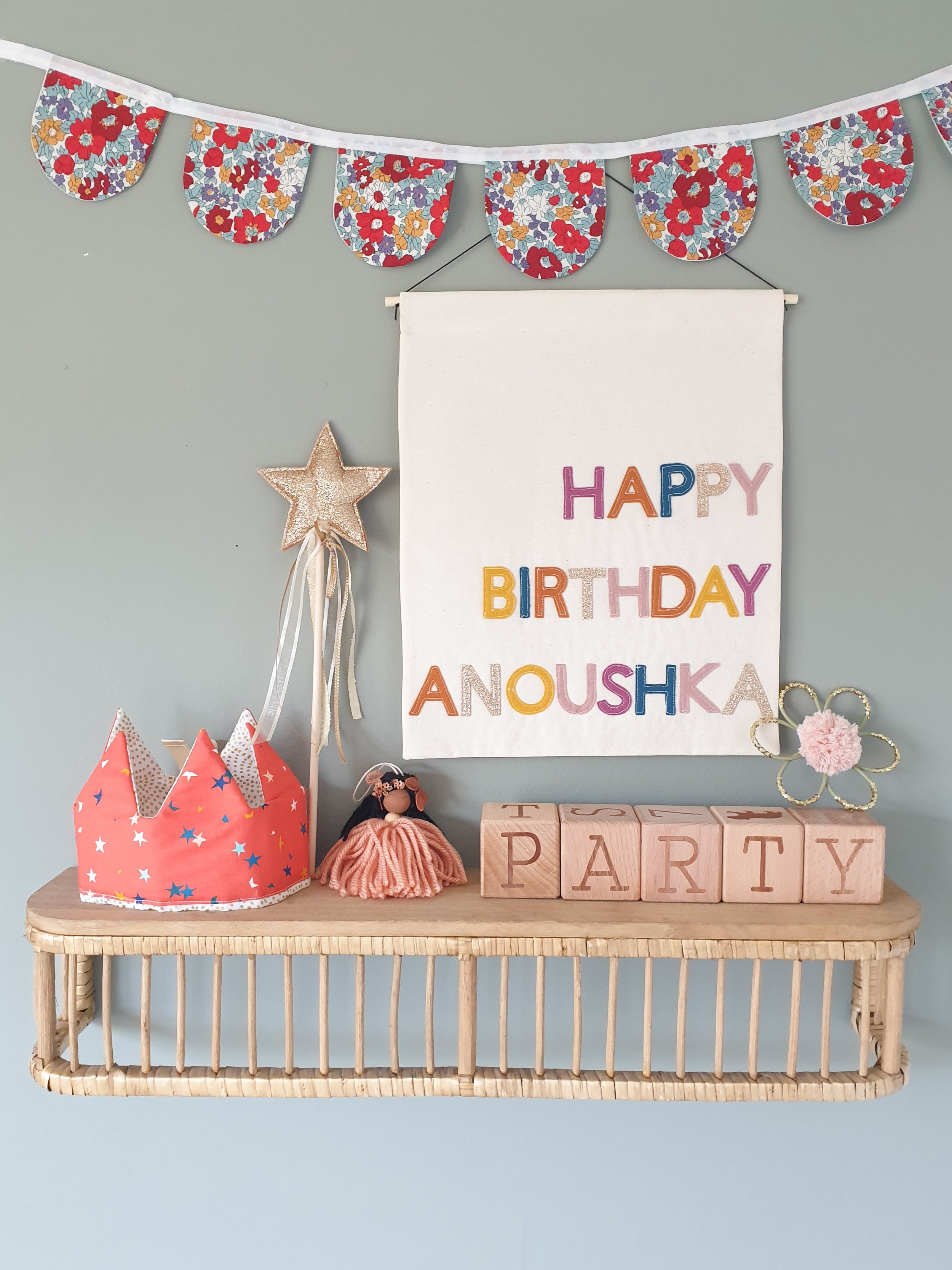 Handmade personalised birthday banner hanging in children's room.