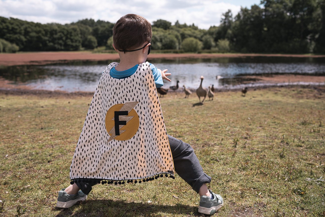 Boy wearing a monochrome superhero cape using his powers. (Copy)