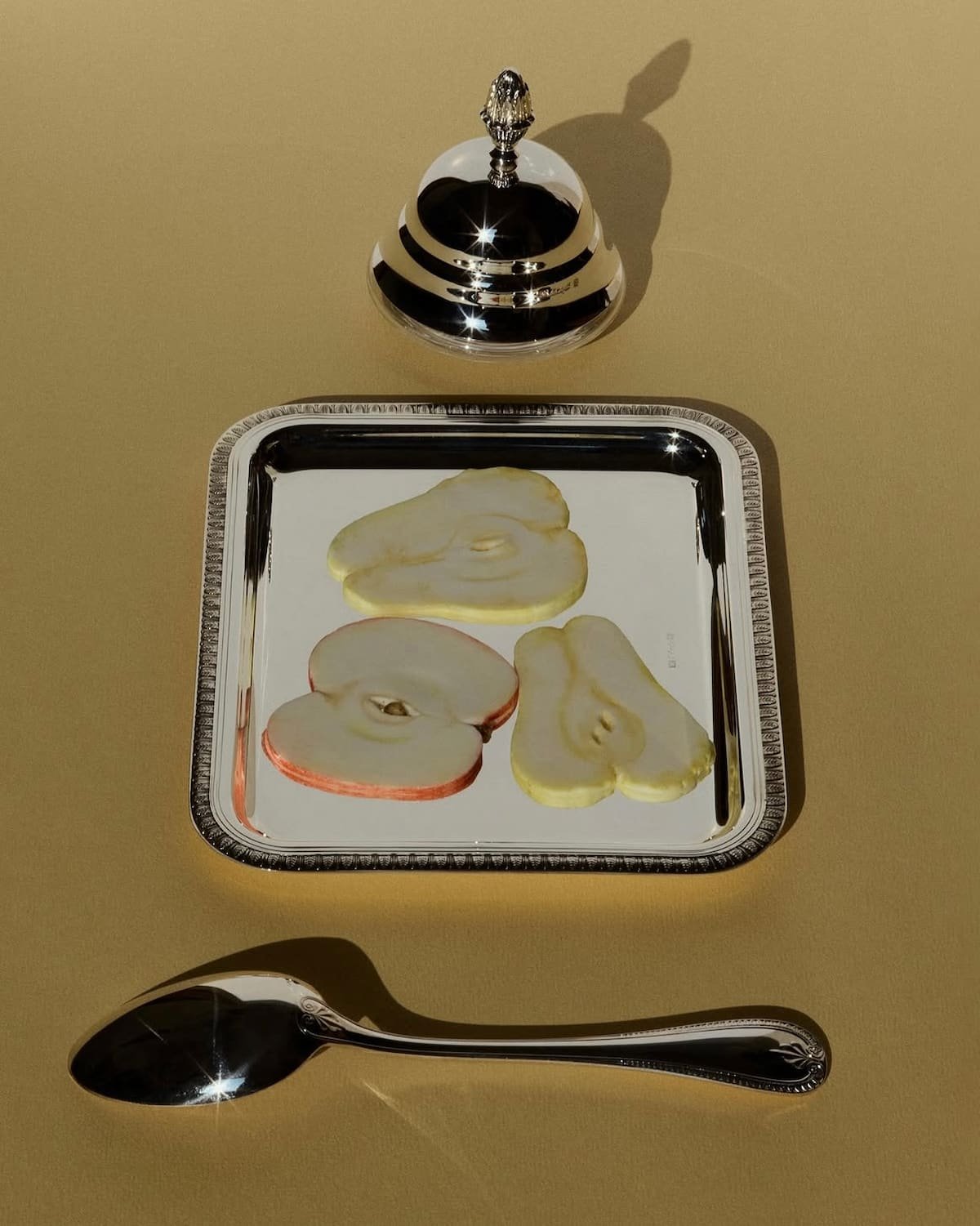 Still life fashion concept with silver tray, sliced pear and refined editorial composition.