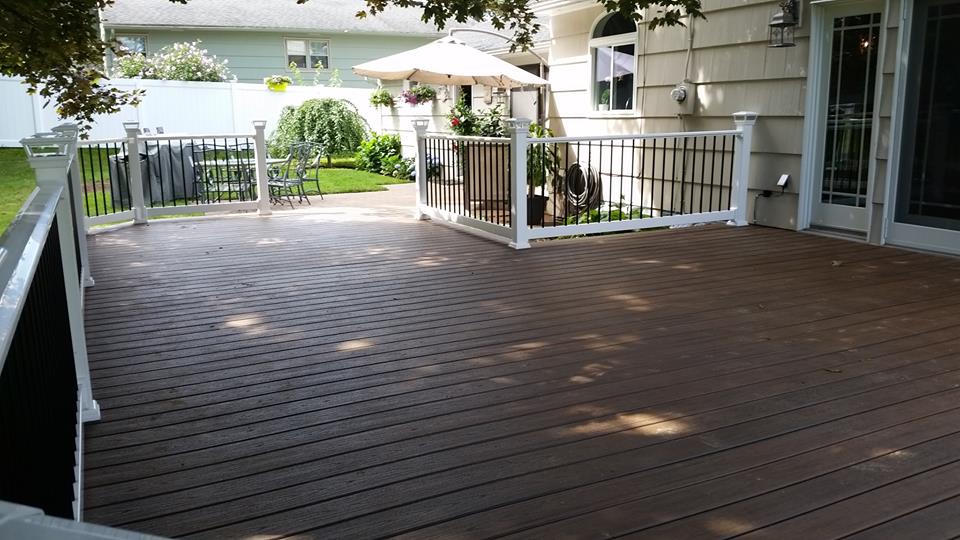 A dark wood deck with white and black fencing.