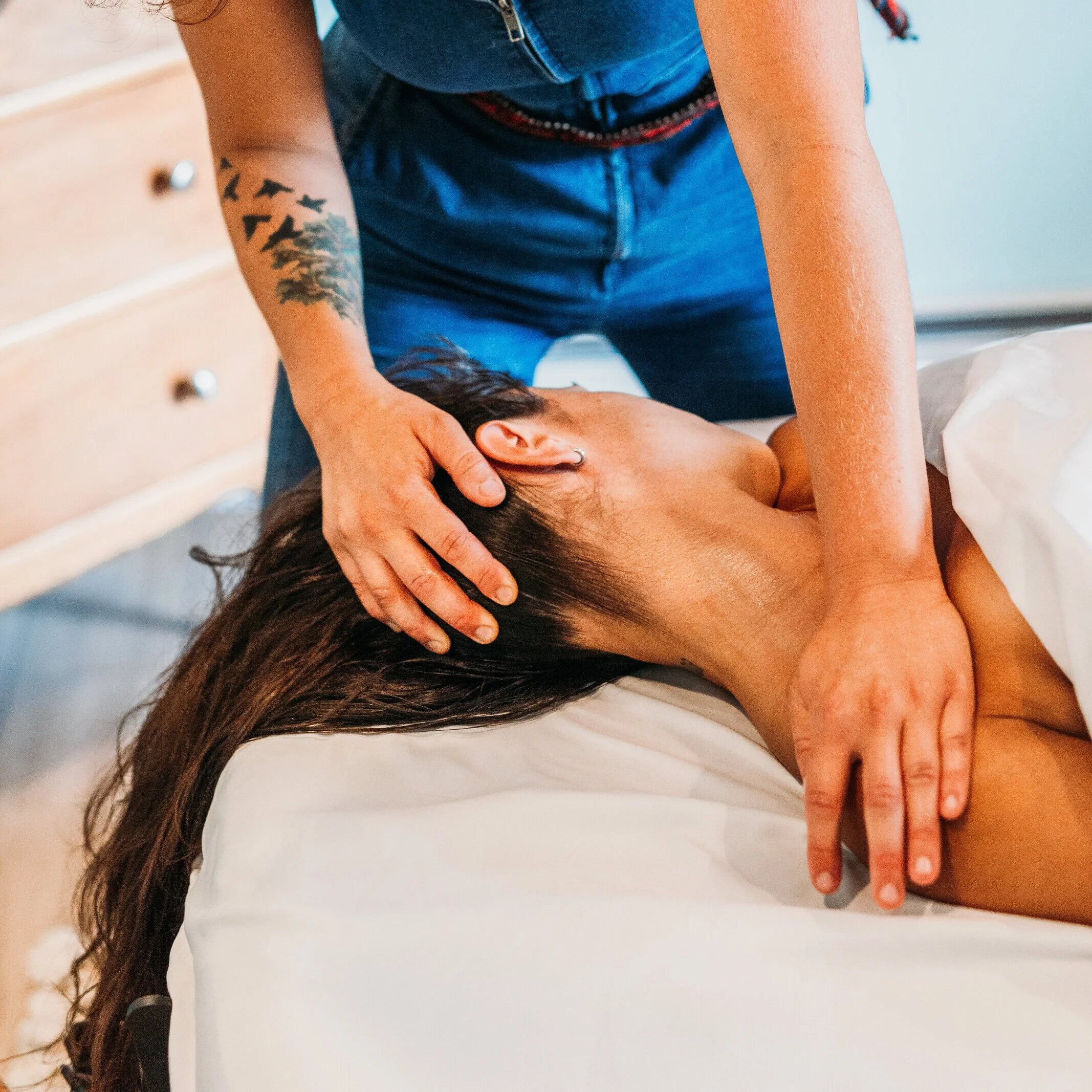 A person receiving a massage from a massage therapist in a spa or massage room.