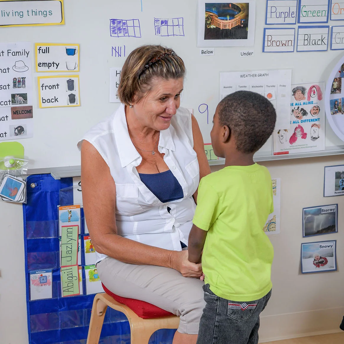 A teacher has a conversation with a student. By maintaining low classroom ratios, teachers are able to foster each child’s sense of self-worth. Credit: Childcare Resources