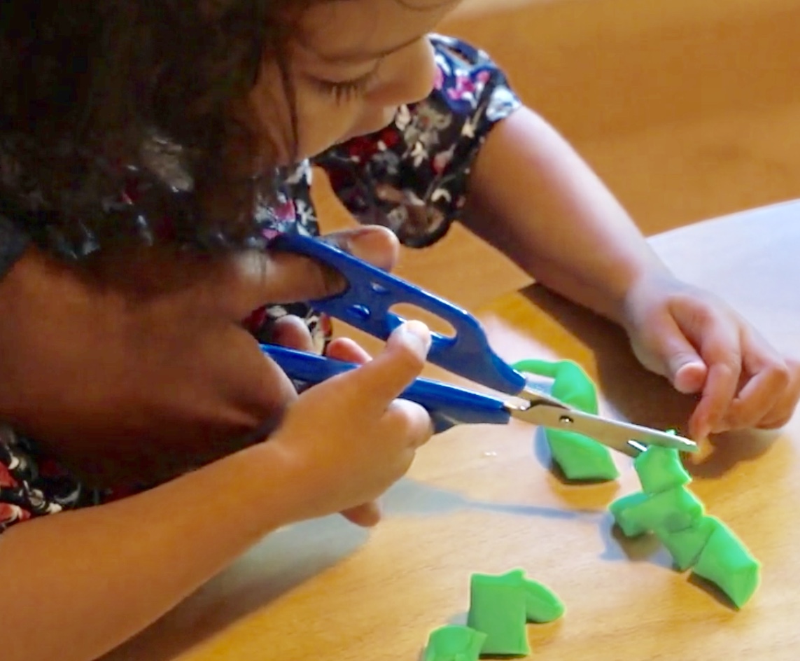 Using hand over hand method to teach scissors skill