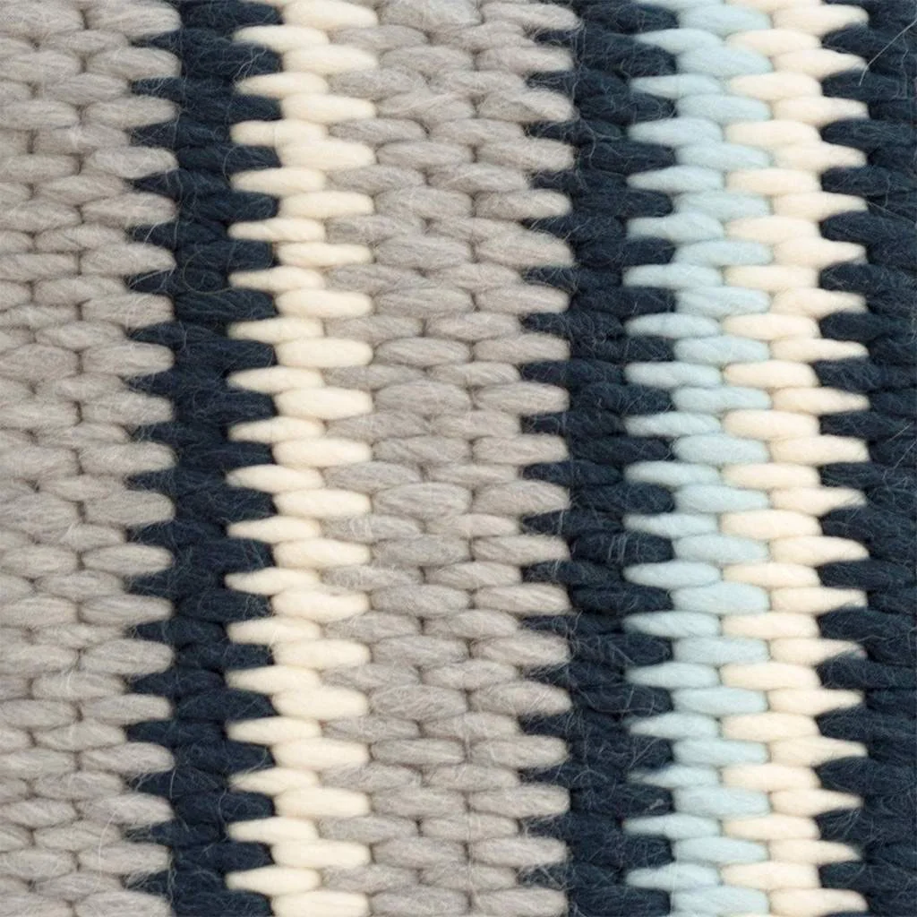 Close up of needlepoint stitches for navy blue and gray stripe cushion.