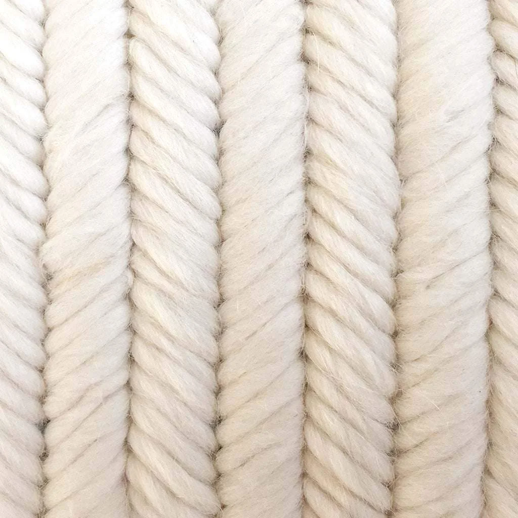Detail view of textured pillow in ivory cream herringbone pattern. Hand stitched needlepoint.
