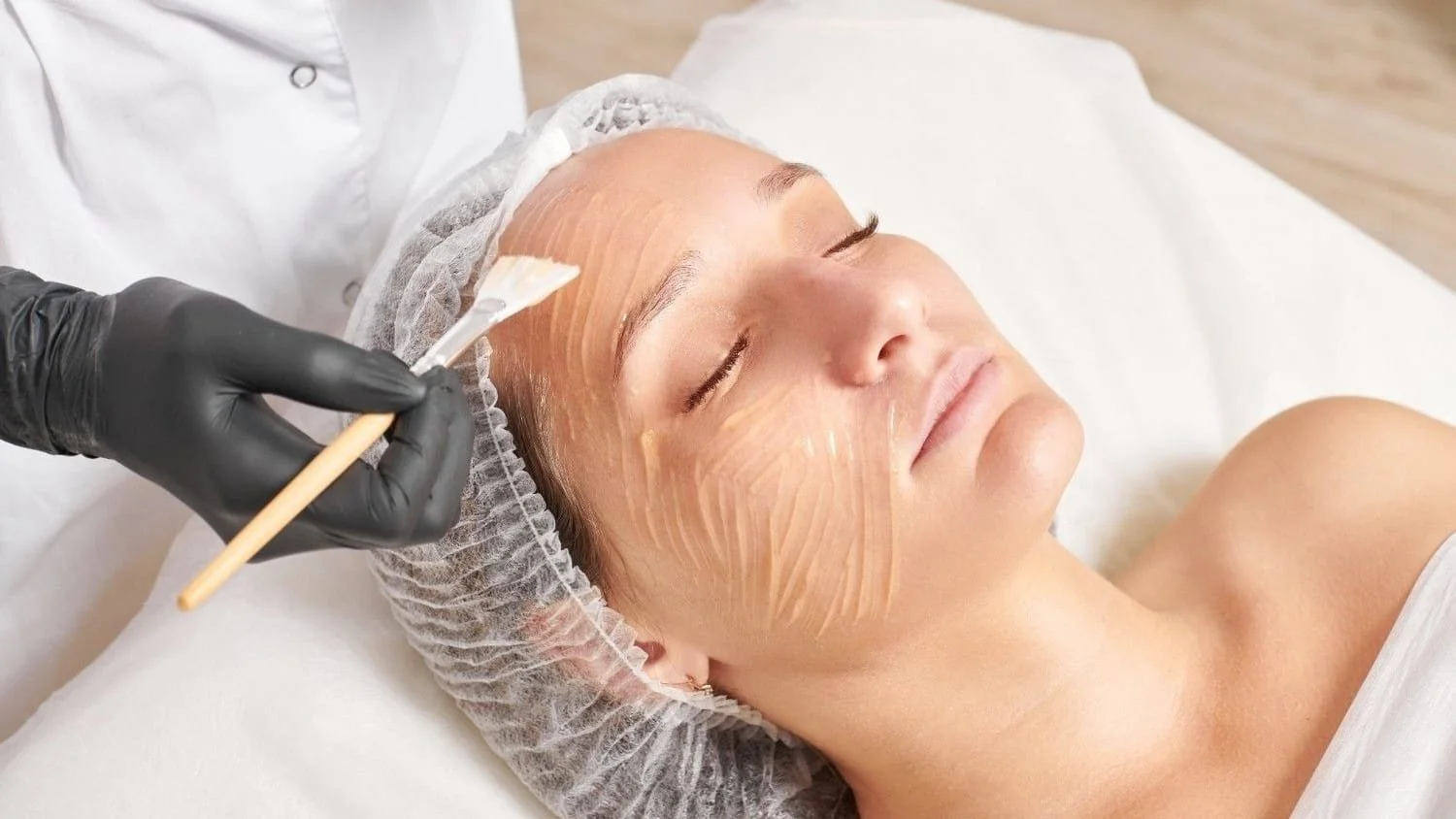 Esthetician applying chemical peel mask