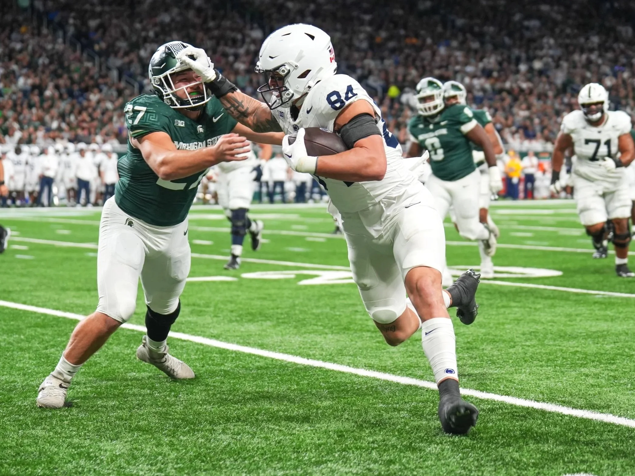 Penn State Nittany Lions tight end Theo Johnson (84) stiff-arms Michigan State Spartans linebacker Cal Haladay (27) during the second half of a college football game at Ford Field in Detroit, Michigan. Penn State defeated Michigan State 42-0 to claim