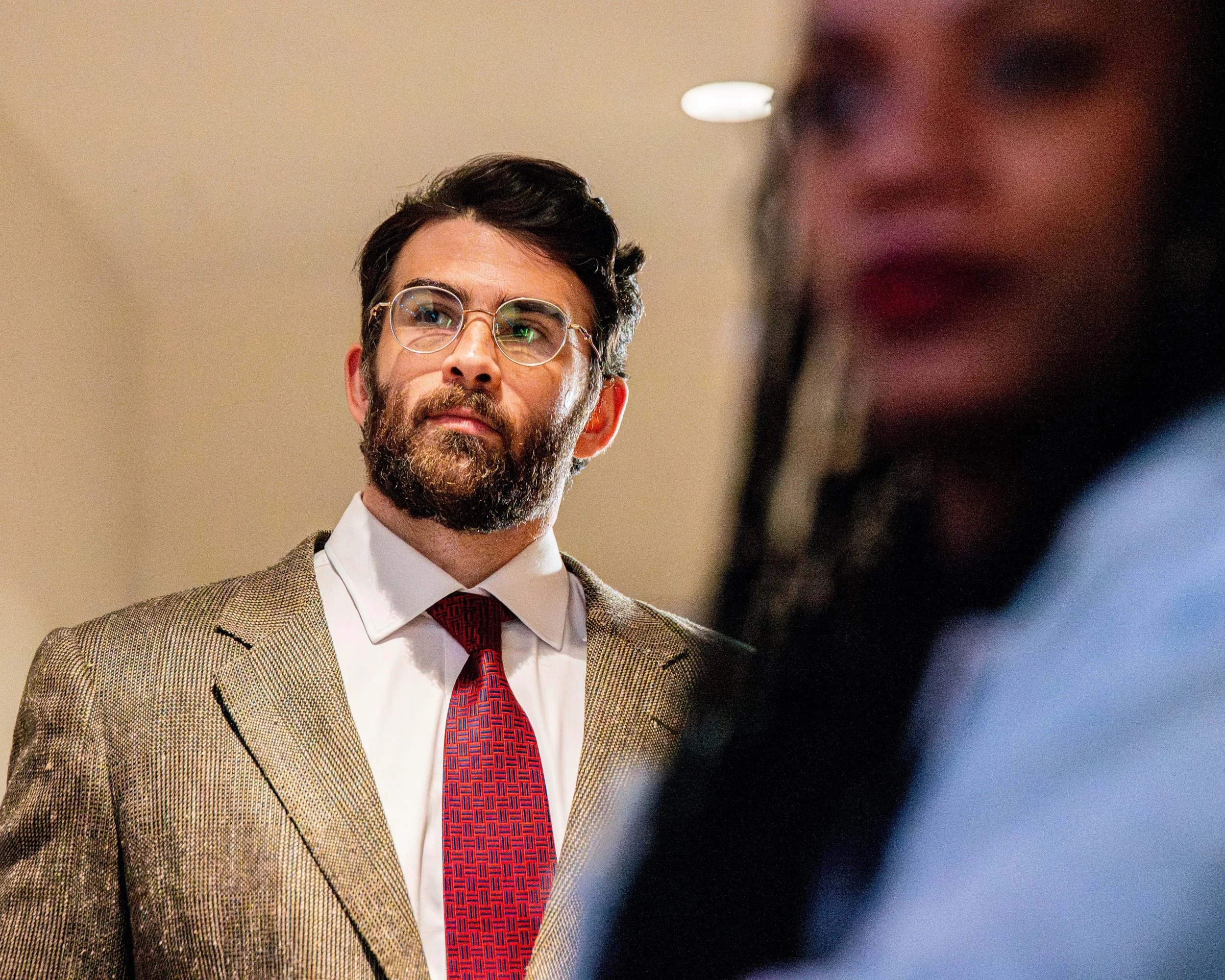 Political commentator Hasan Piker looks on as U.S. Rep. Rashida Tlaib addresses the crowd during a campaign rally at the University of Michigan in Ann Arbor, Mich., Tuesday, April 7, 2026.