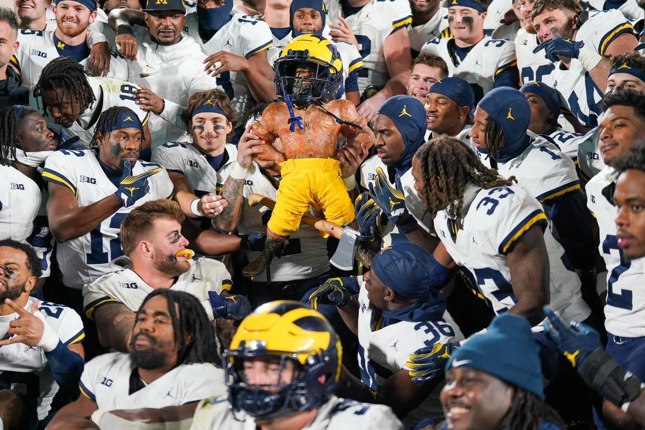 Michigan football players celebrate with the Paul Bunyan Trophy on the field at Spartan Stadium in East Lansing, Mich., Saturday, Oct. 21, 2023. Led by quarterback J.J. McCarthy’s four touchdown passes, the No. 2 Wolverines secured a 49-0 shutout vic