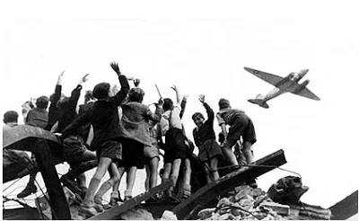 Berlin youth cheering a ' rosinen bomber .’