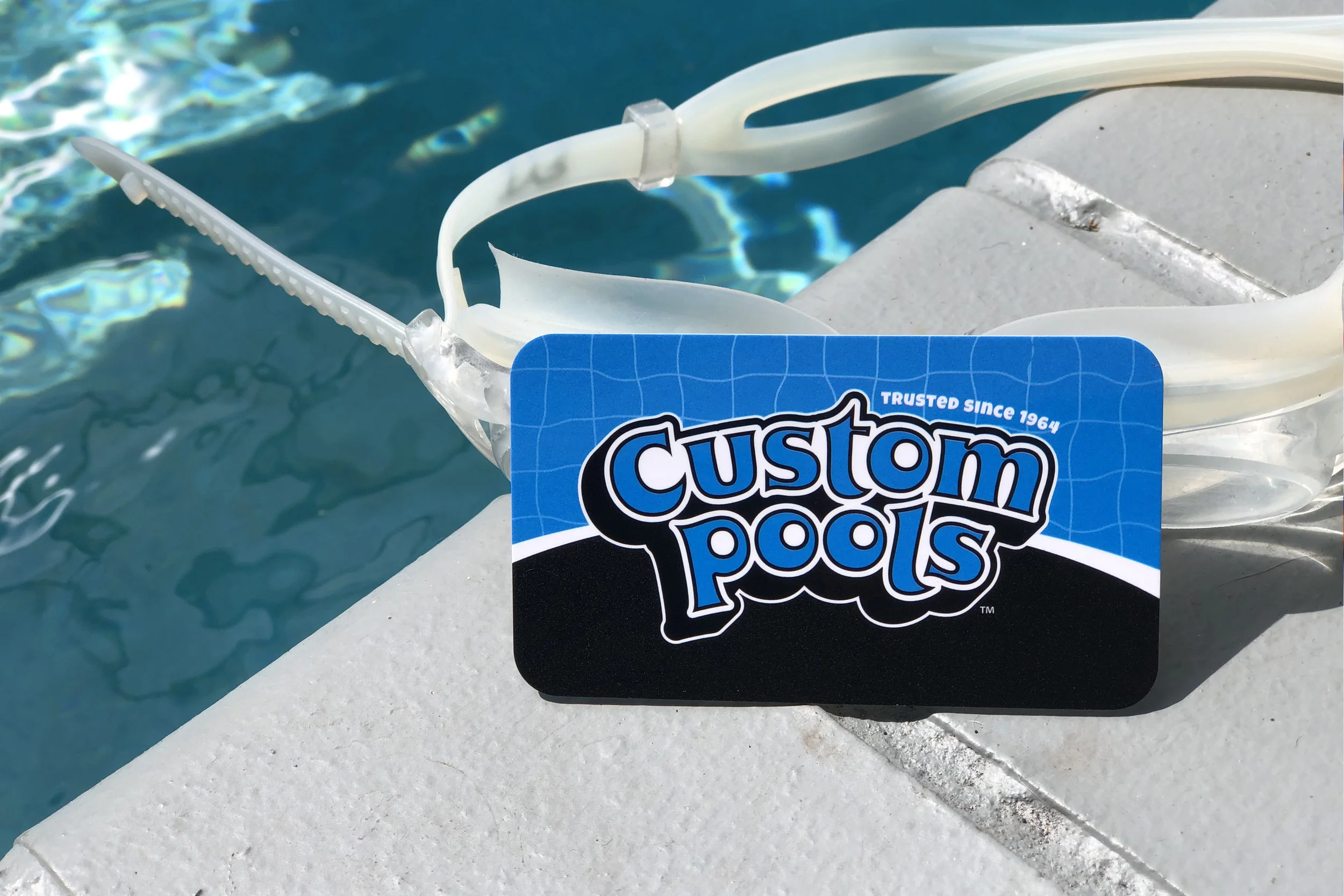 silk laminated with rounded corners business card printed by Print Hub a Miami sign shop next to a pool