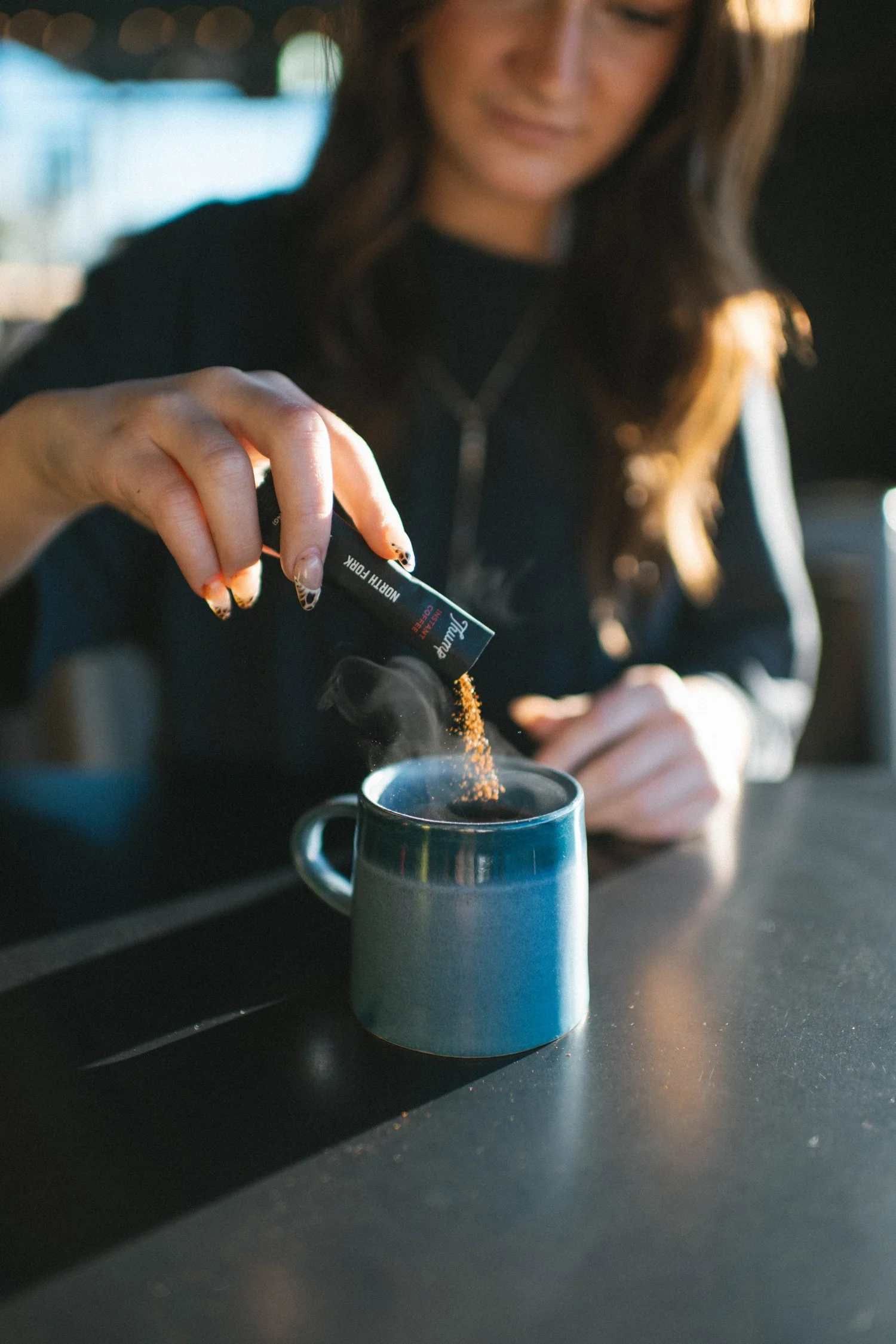 Pouring Thump North Fork instant coffee into a mug at home