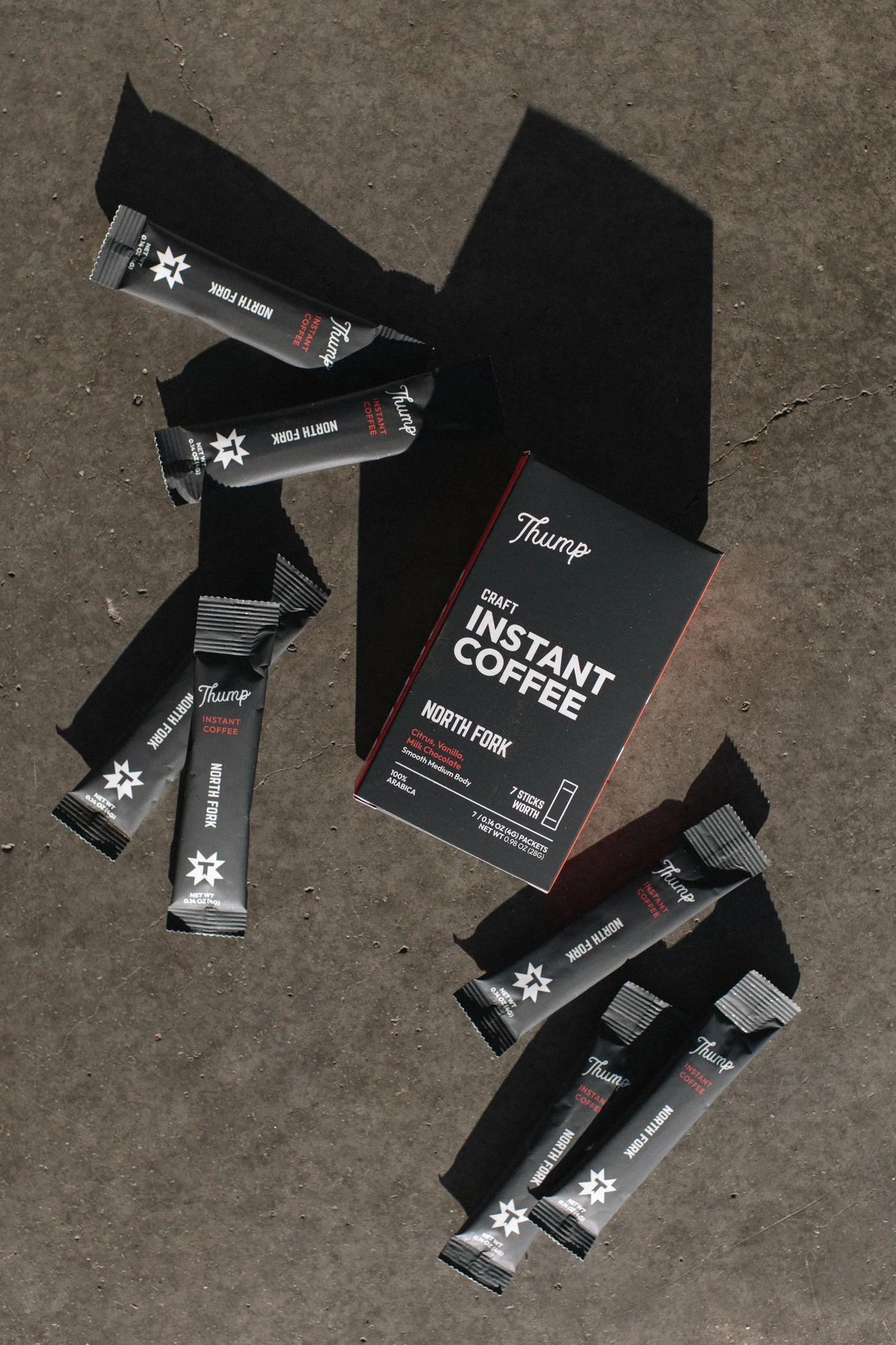 Thump North Fork instant coffee stick packs and box laid out on concrete