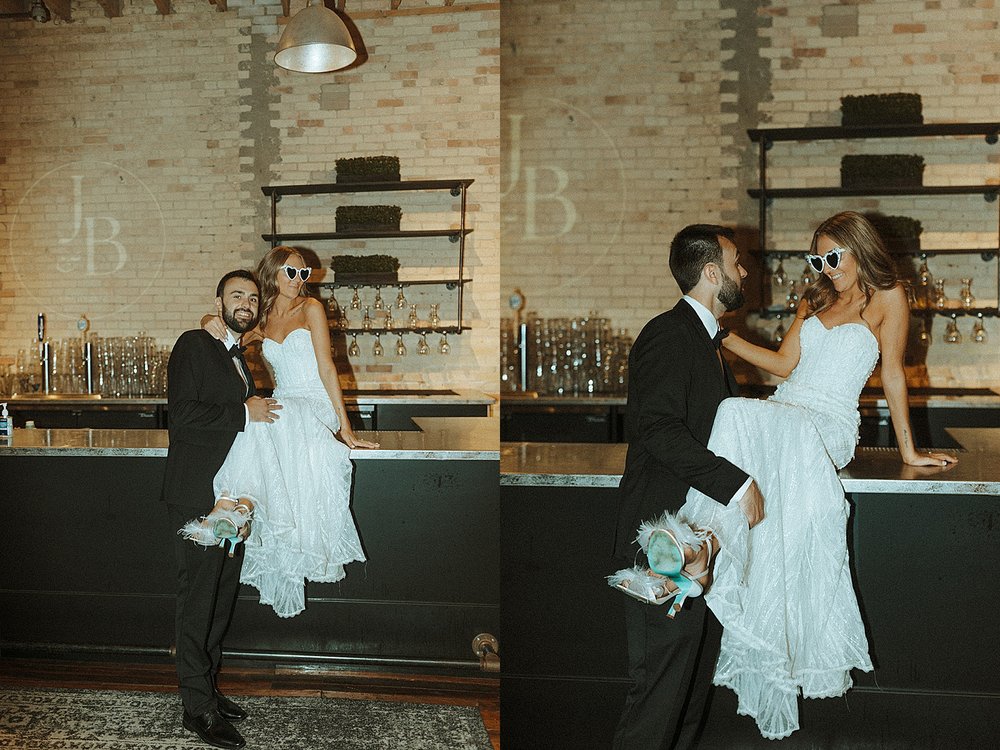  bride and groom sitting on bar top at The Goei Center 