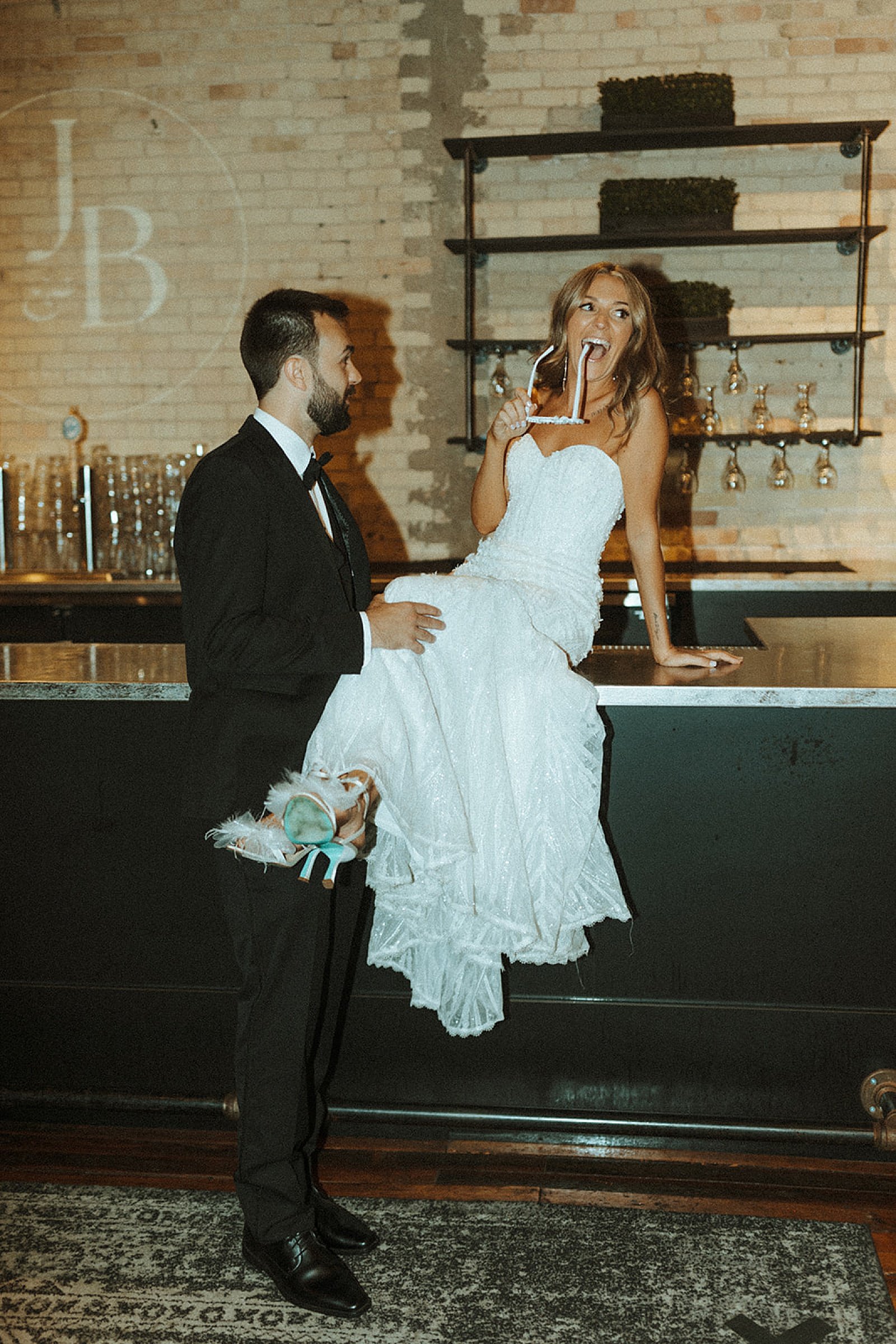  bride sitting on a bar top with groom by Steph Photo Co 