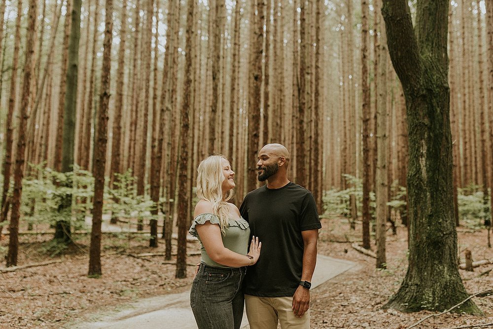  couple embracing in woods at Grand Haven Engagement 