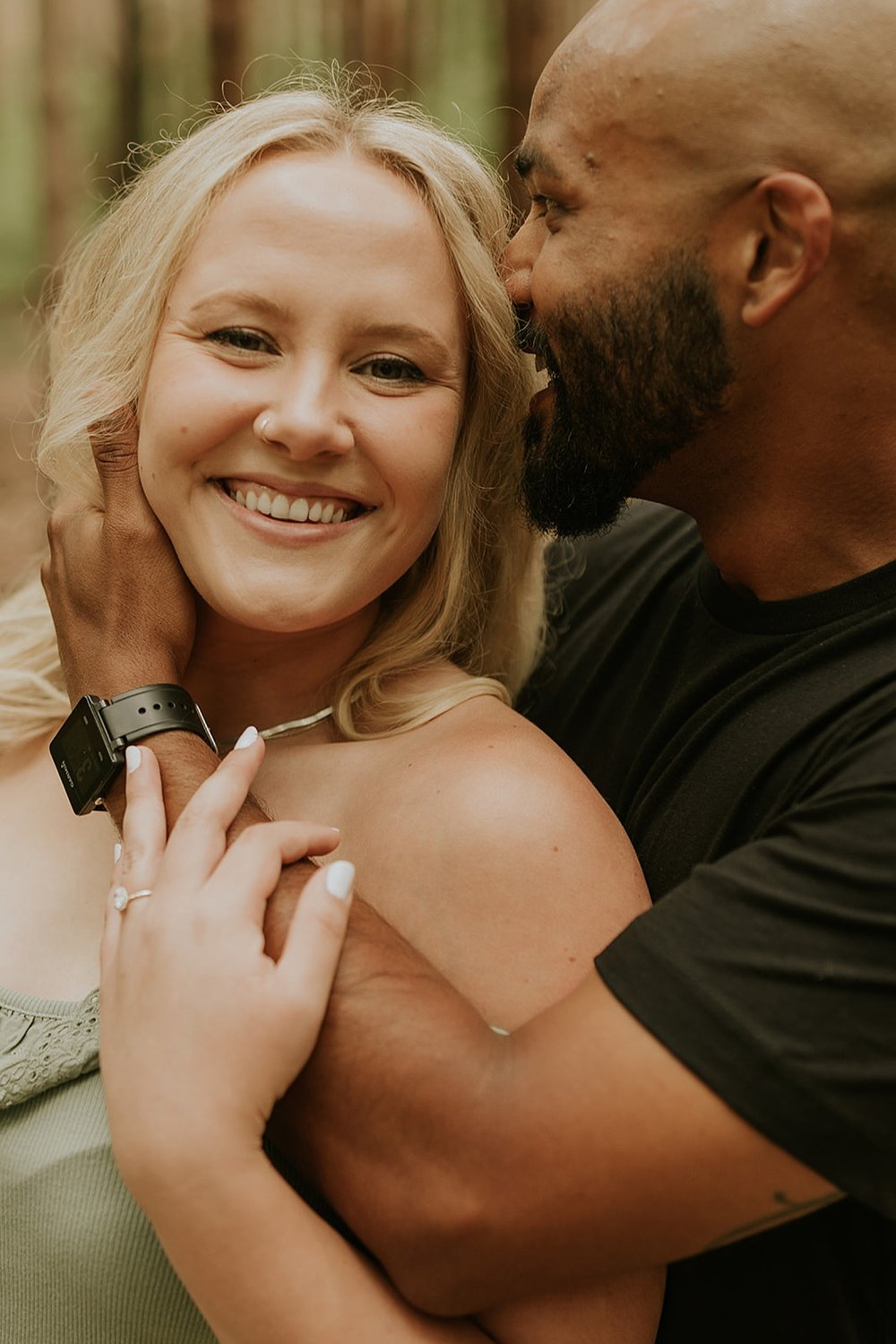  blonde woman and black man kissing at Grand Haven Engagement 