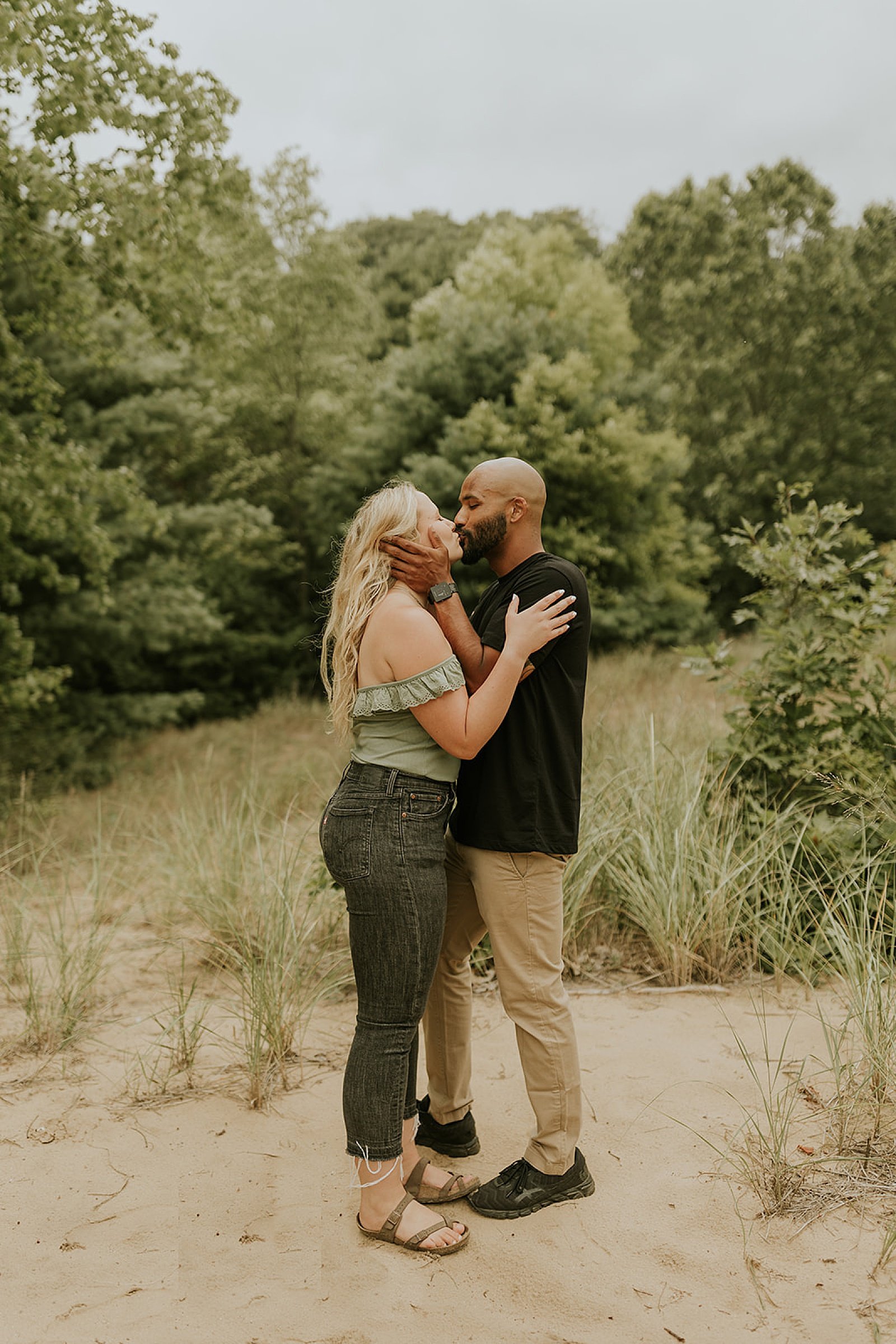  man and woman kissing outside by trees by Steph Photo Co 