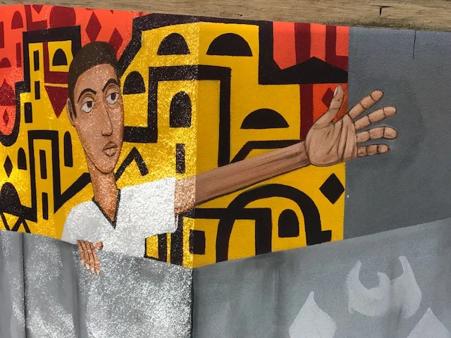 Ahmad climbing over the Apartheid wall reaching for the Key of return.