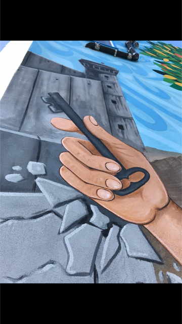 The key of return in the other hand, as its being handed to the youth, Amals hand breaks through the wall with her hand.