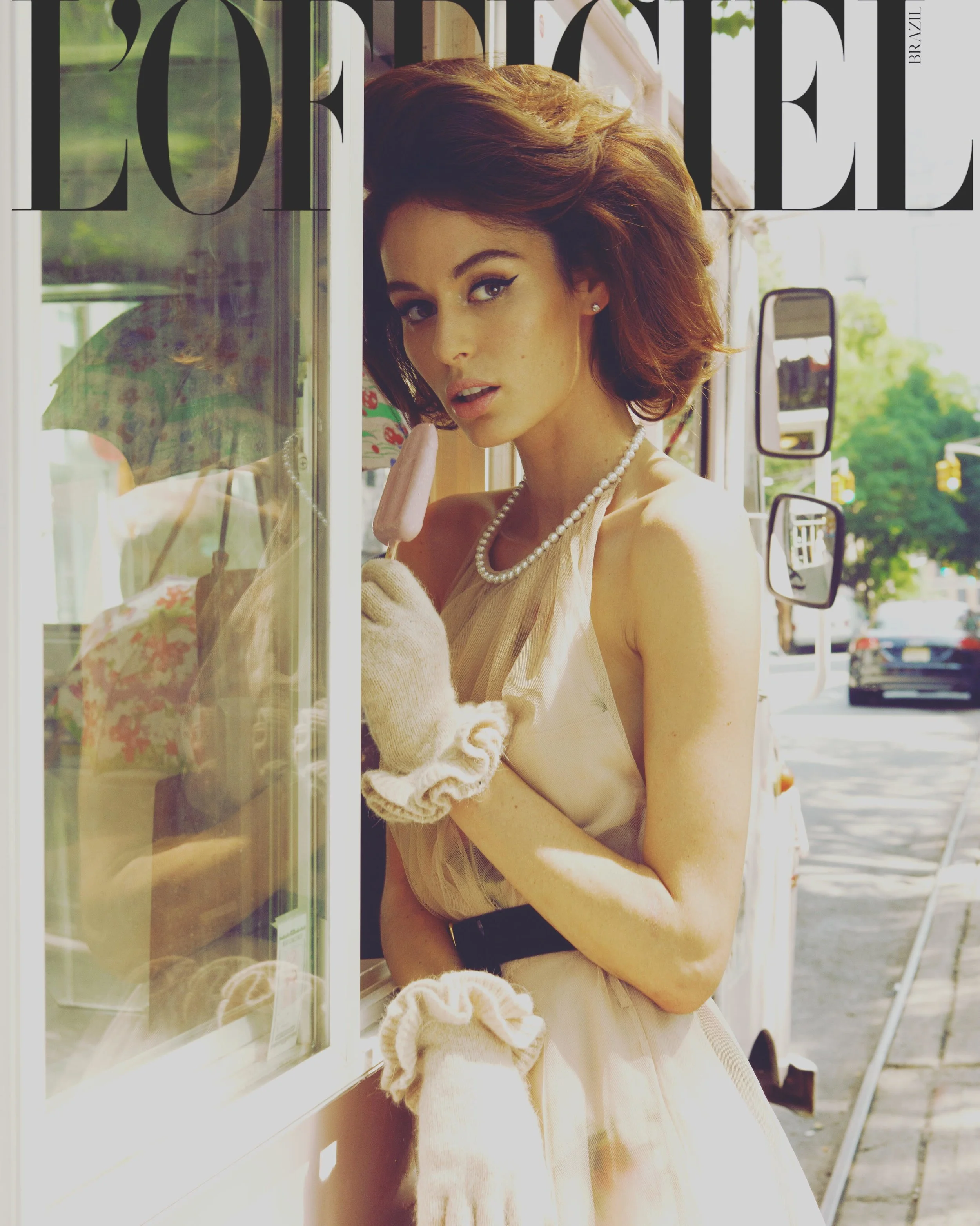 L'Officiel cover of a model with auburn curls and pearls by a window by celebrity photographer Steven Gomillion