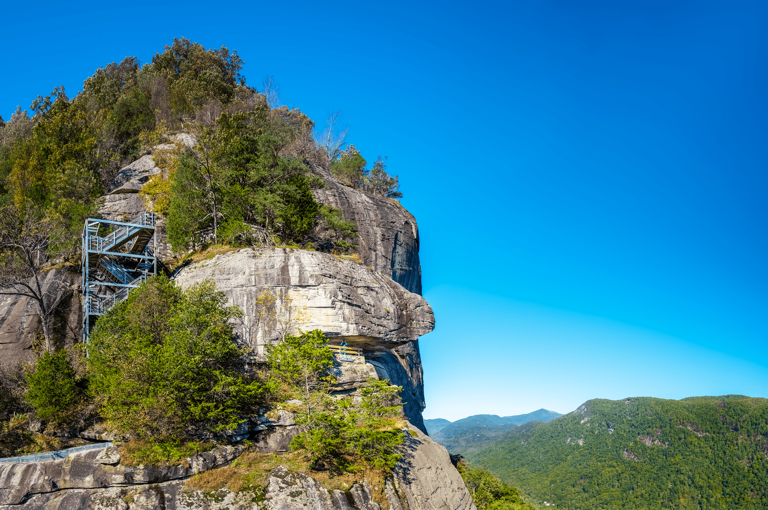 Behind Chimney Rock is the famous Opera Box covered by an imposing rock overhang. The staircase to the left is part of the Exclamation Point Trail , which connects to the Skyline Trail .