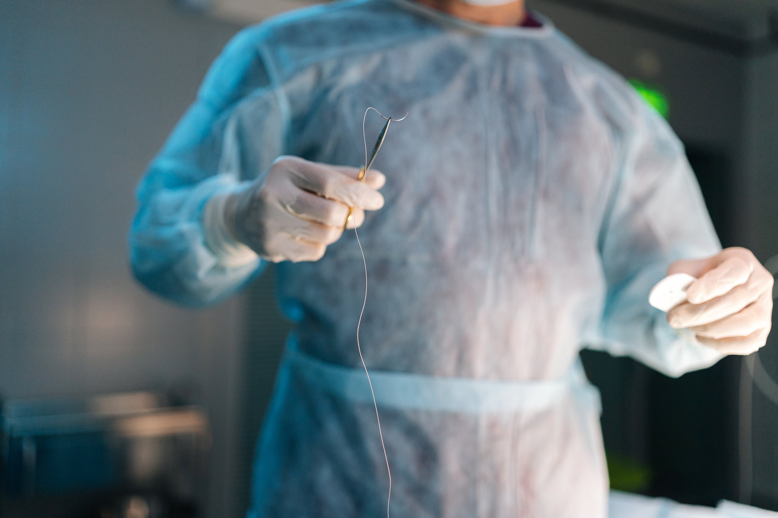 closeup-hands-unrecognizable-professional-surgeon-wearing-uniform-holding-forceps-with-suture.jpg
