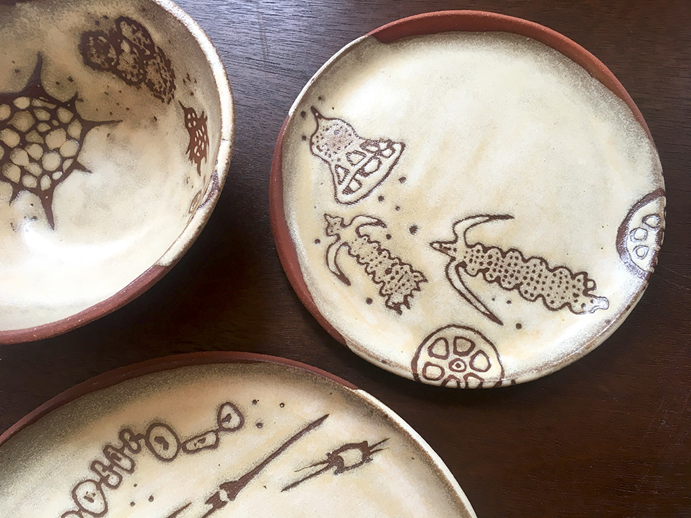  Detail of place setting with small bowl, 7” &amp; dinner plate in créme brûlée on red clay 