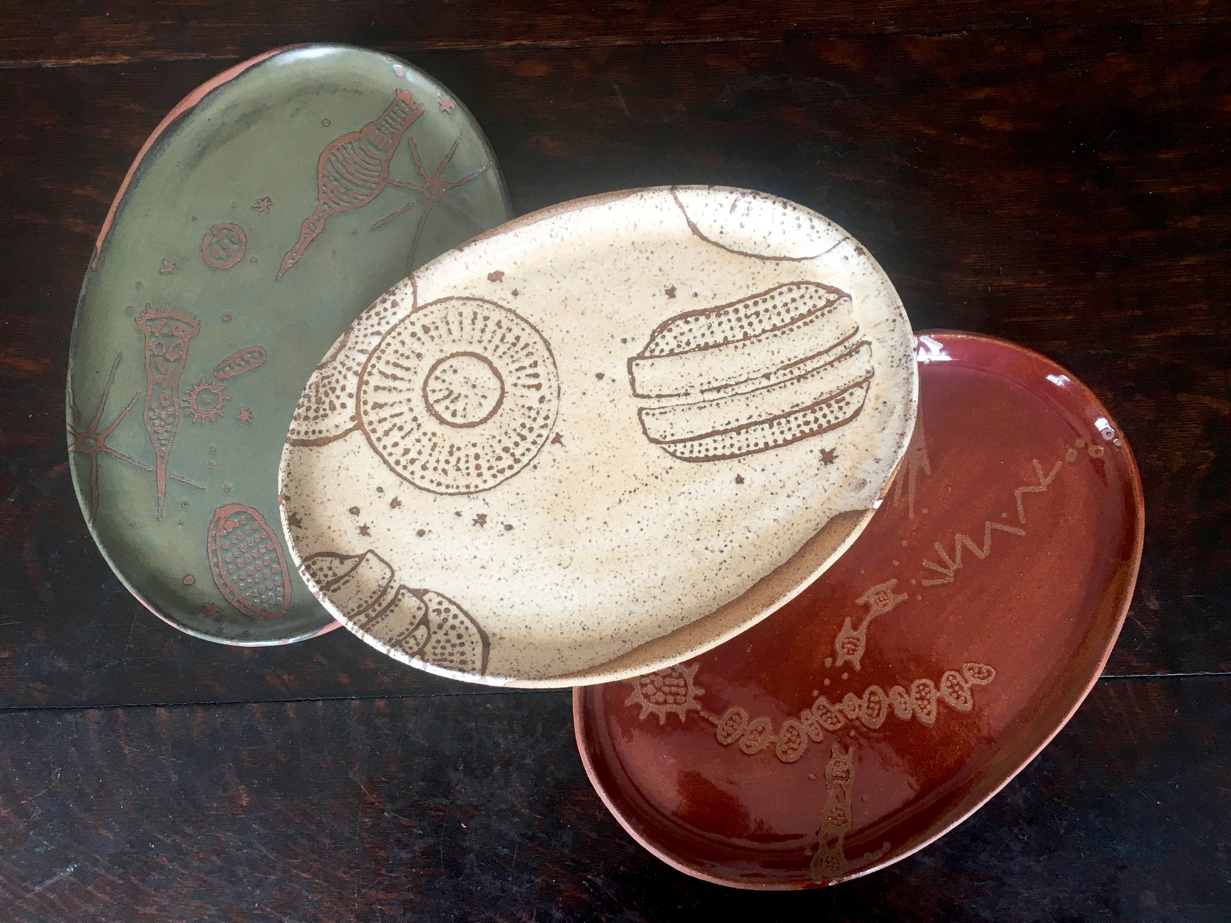  Platters are oval in small, medium &amp; large with a wide rim on the grand platter   Trio in moss on red clay, créme brûlée on speckled clay &amp; plum on red clay 