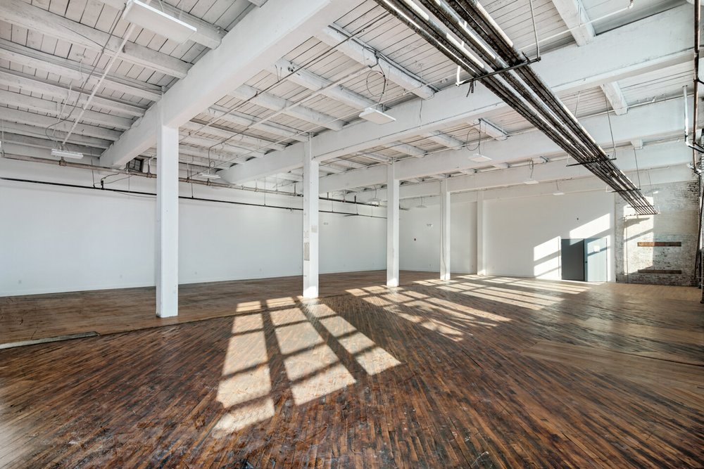Open studio with wood floors and big windows, suited to dance and fitness