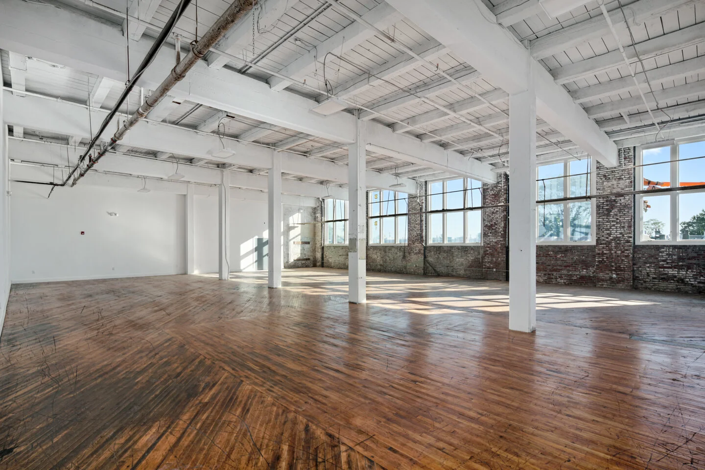 Open studio at the original D Street campus with white columns, wood floors and rows of windows