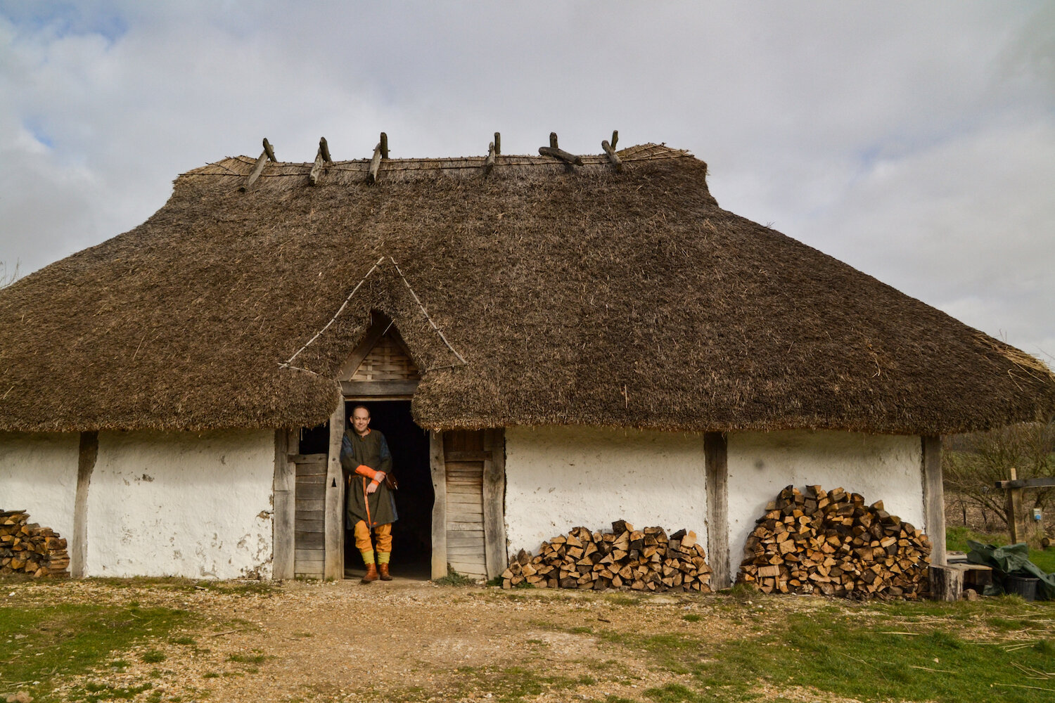 Butser Ancient Farm Saxon Hall with reenactor