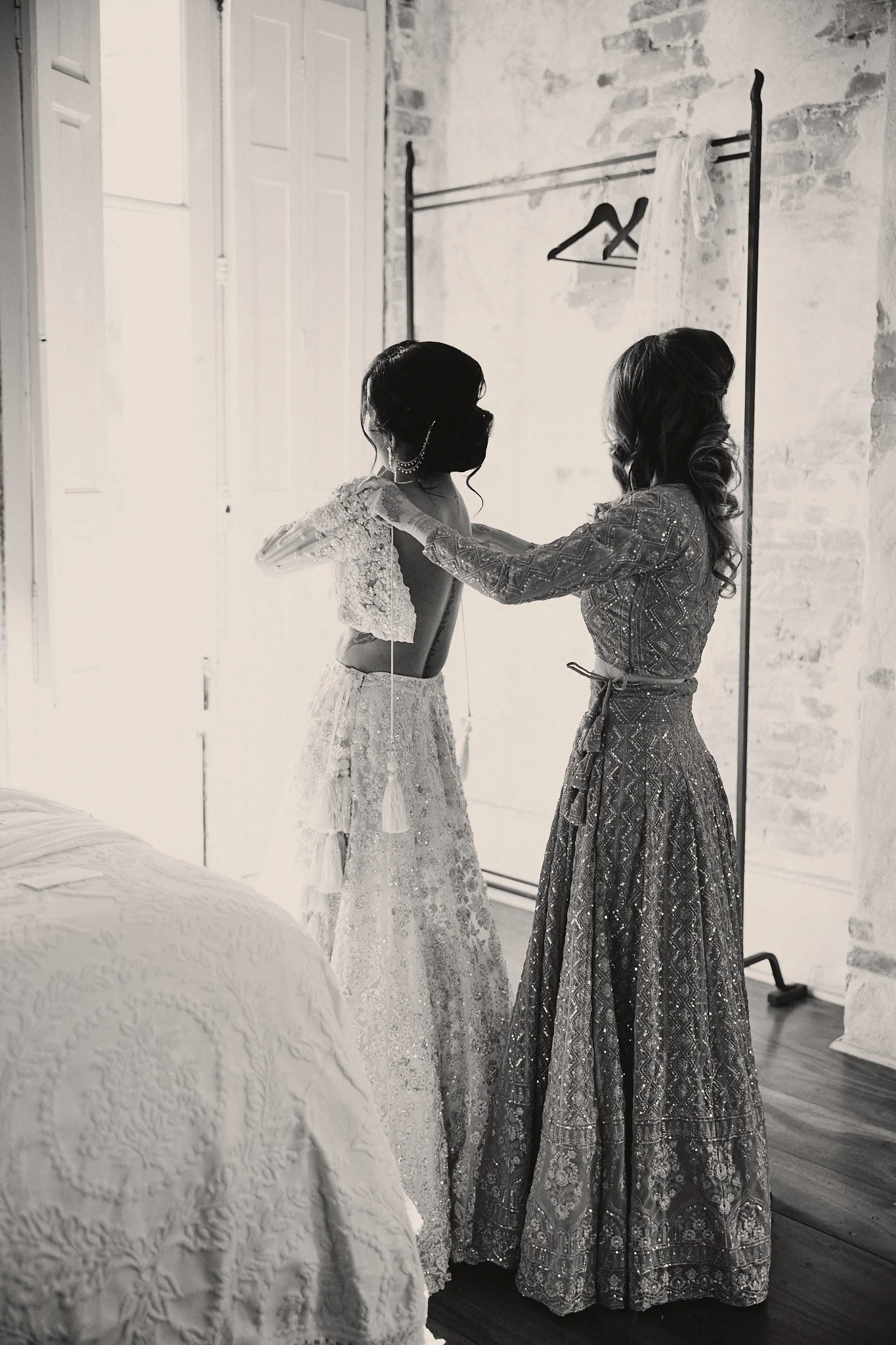 A bride being helped into her lehenga in the second-floor bridal suite at Race & Religious in New Orleans
