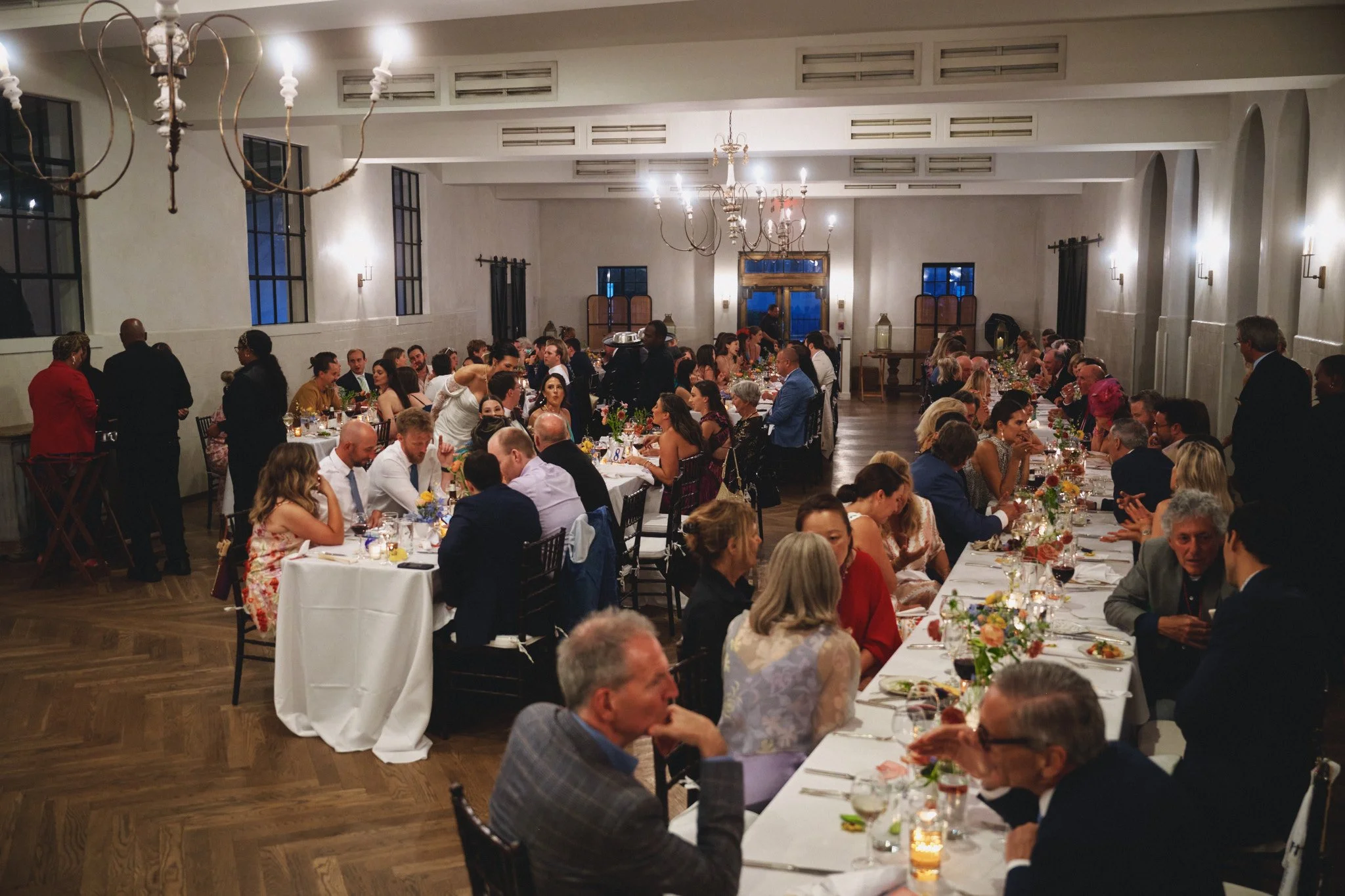  Guests at dinner beneath the chandeliers in the arched reception hall at Il Mercato in New Orleans 